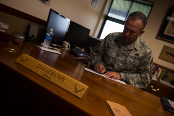 U.S. Air Force Chief Master Sgt. David Kelch, 23d Wing command chief, signs an Air Force Assistance Fund registration form April 7, 2015, at Moody Air Force Base, Ga. The AFAF will be accepting contributions from Moody personnel until May 1, 2015. (U.S. Air Force photo by Airman 1st Class Dillian Bamman/Released)