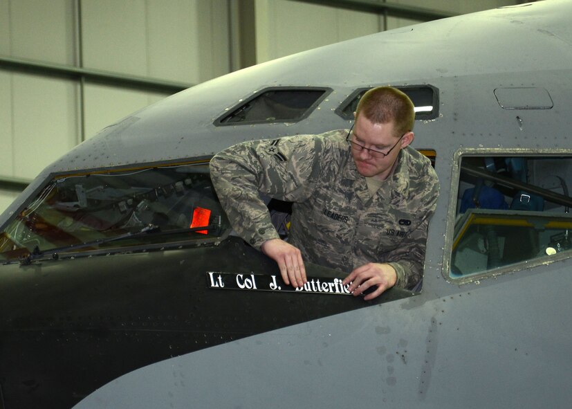 U.S. Air Force Airman 1st Class Cody Leaders, 100th Maintenance Squadron Aircraft Structural Maintenance technician from Elizabeth, Colo., places a name plate of the incoming 100th Operations Support Squadron commander on a KC-135 Stratotanker April 2, 2015, on RAF Mildenhall, England. The new commander, U.S. Air Force Lt. Col. Jay Butterfield, incoming 100th OSS commander, was previously the 100th Air Refueling Wing director of staff. (U.S. Air Force photo by Gina Randall/Released)