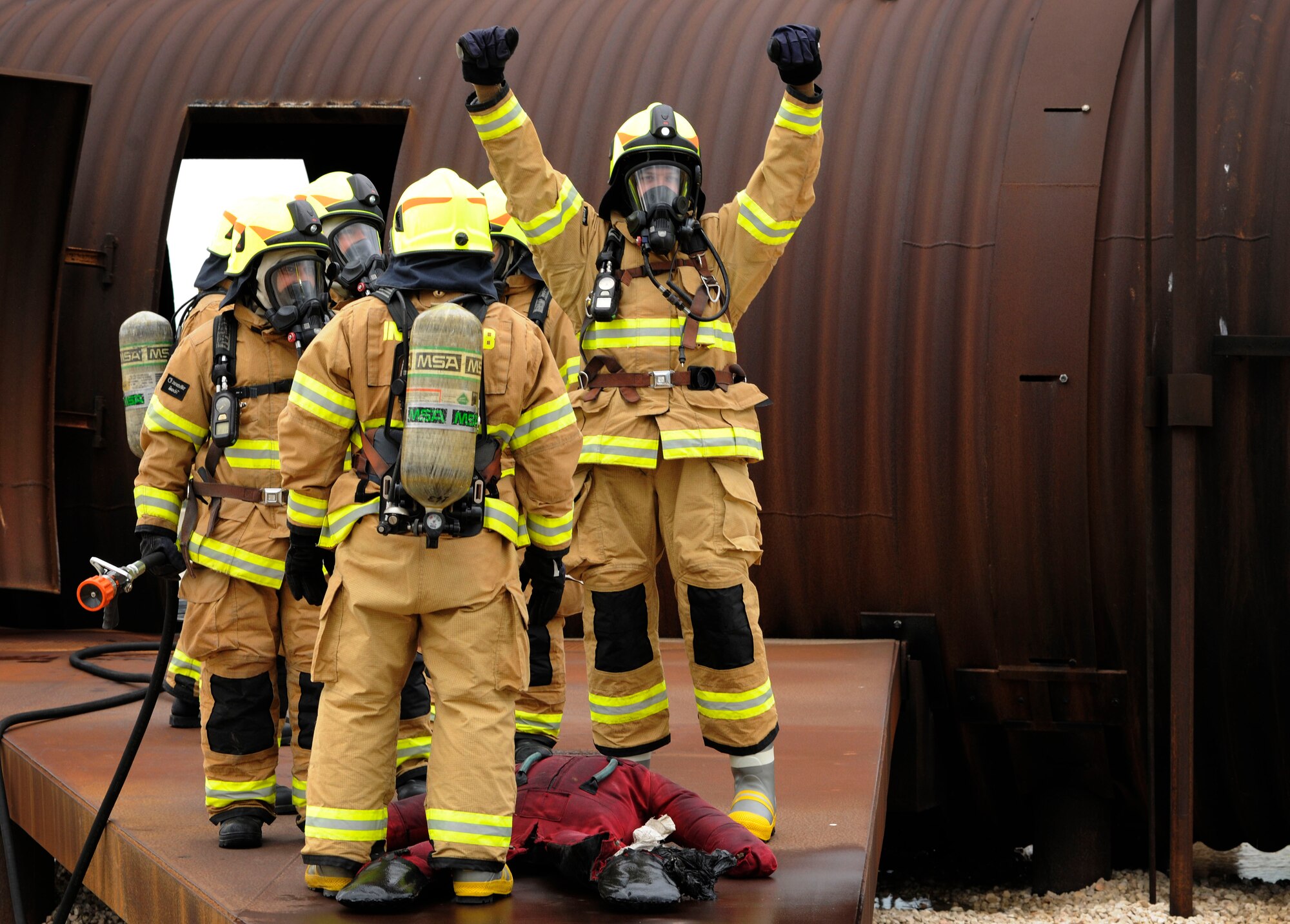 Col. Craig Wills, 39th Air Base Wing commander, raises his arms in celebration after successfully rescuing a dummy victim during a firefighter training April 2, 2015, at Incirlik Air Base, Turkey. Wills and Chief Master Sgt. Vegas Clark, 39 ABW command chief joined members of the 39th Civil Engineer Squadron Incirlik Fire Emergency Services in a training to gain a better understanding of the duties and responsibilities of firefighters. (U.S. Air Force photo by Senior Airman Krystal Ardrey/Released)