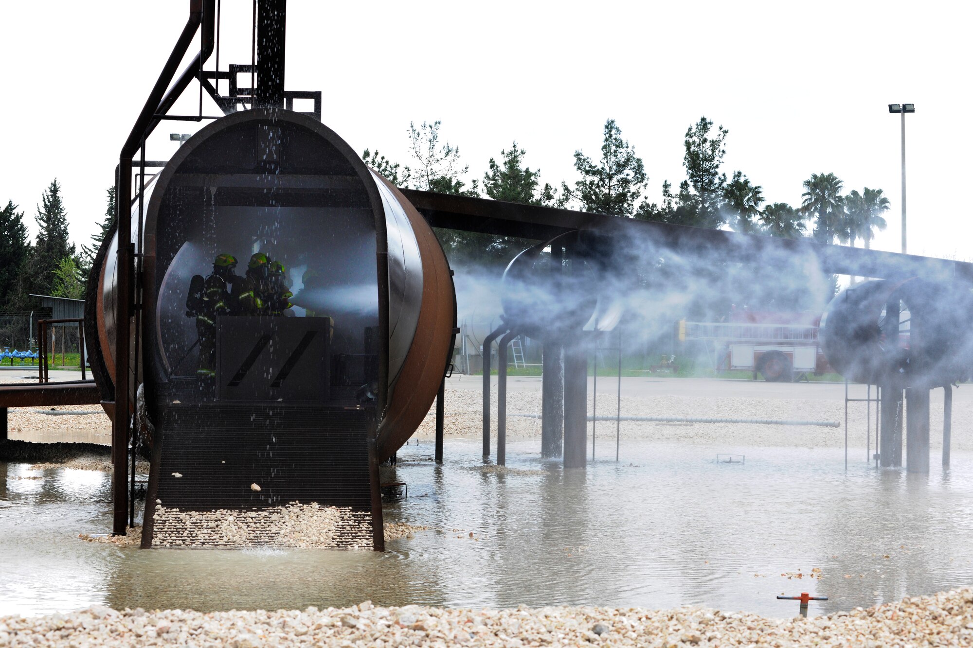 Firefighters from the 39th Civil Engineer Squadron Incirlik Fire Emergency Services and leadership from the 39th Air Base Wing practice extinguishing fires inside a simulated aircraft April 2, 2015, at Incirlik Air Base, Turkey. The event was part of the Out Connecting with Airmen program, which allows the base commander and command chief experience a different job around base each week. (U.S. Air Force photo by Senior Airman Krystal Ardrey/Released)