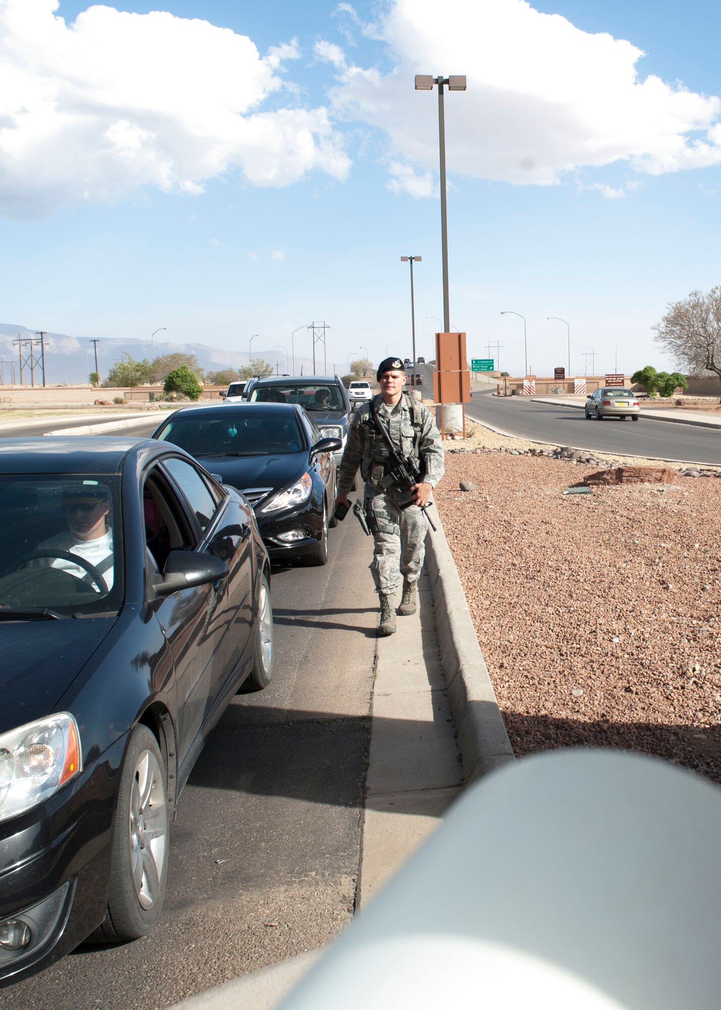 (HOLLOMAN AIR FORCE BASE, N.M.) Airman 1st Class Devin Lewis, 49th Security Forces patrolman, walks back from checking members of Team Holloman’s identification cards at Holloman Air Force Base, N.M. April 8, 2015. “I choose to join the military to help me grow up and mature in life,” said Lewis. Lewis maintains his motivation by knowing the ones that came before him made the military what it is, and he strives to keep it that way. Lewis uncle and grandfather were in the military and were his role models. “What better way honor them, then to follow their footsteps,” said Lewis. Lewis feels that he contributes to the military mission by keeping the personnel and assets on base safe. Lewis said he always wanted to be a cop and joining the military as a security forces patrolman was the ideal job for him. Lewis has been in for two and a half years and will be going to military working dog technical training in a few months. (U.S. Air Force photo by Staff Sgt. E’Lysia A. Wray/Released) 
