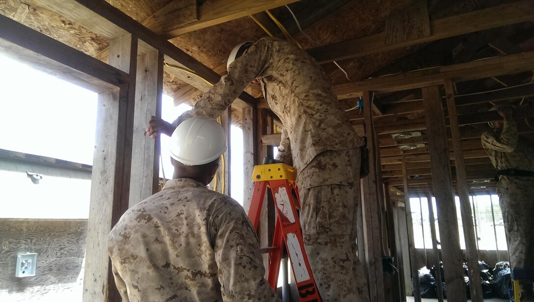 Marines install interior wiring during a field exercise.