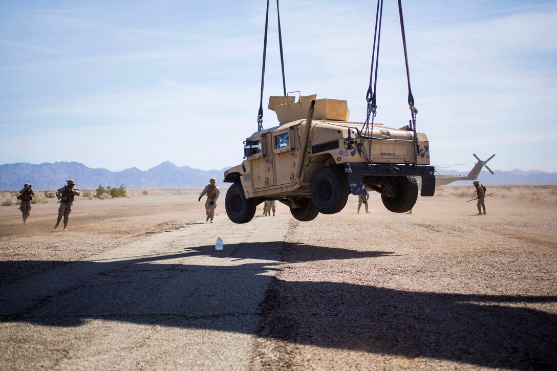 A Humvee is lifted off the ground by a CH-53E Super Stallion helicopter during an external lift during Weapons and Tactics Instructor Course 2-15 on Auxiliary Airfield 2 near Yuma, Ariz., April 3, 2015. 