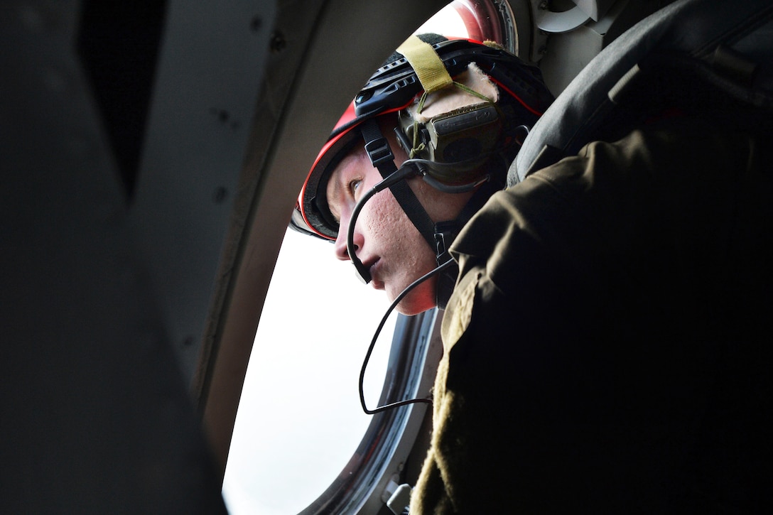 U.S. Air Force Master Sgt. Sam Prescott watches as pararescue jumpers exit a U.S. Coast Guard HC-144 Ocean Sentry aircraft during exercise Operation Orange Flag 2015 at Cape Cod Air Sation, Cape Cod, Mass., March 31, 2015. Prescott is a pararescue jumper assigned to the New York National Guard's 103rd Rescue Squadron, 106th Rescue Wing.