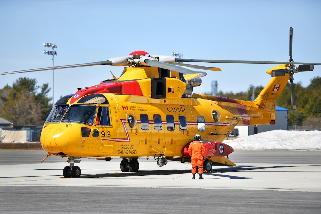 A Canadian airman prepares to board a Canadian CH-149 Cormorant helicopter during exercise Operation Orange Flag 2015 at Cape Cod Air Sation, Cape Cod, Mass., March 31, 2015.