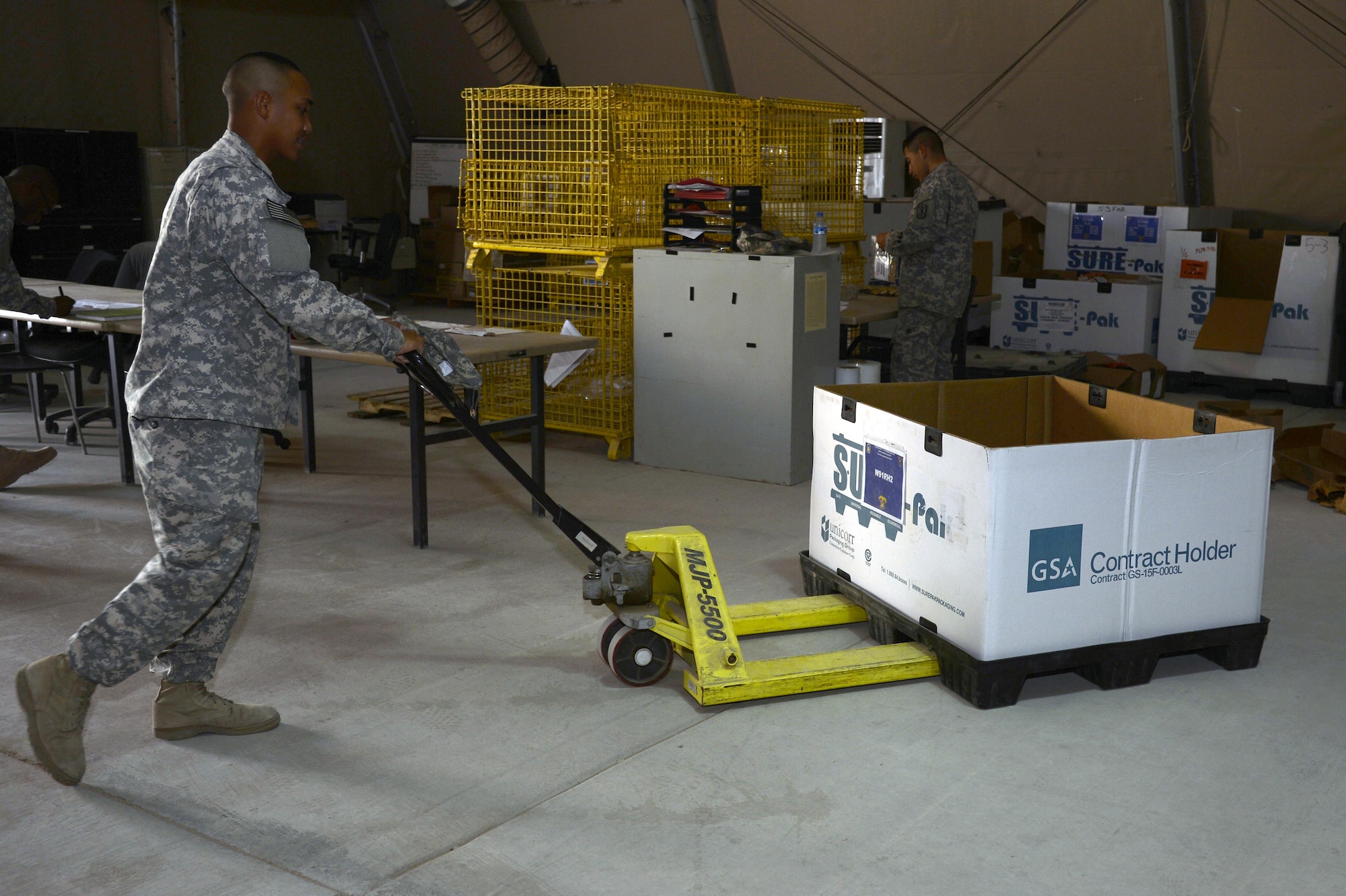 Specialist Raymond, turn-in and shipping NCO in-charge, moves recoverable/repairable cargo to be prepared for timely shipping at an undisclosed location in Southwest Asia April 6, 2015. Surat led his team with material handling and shipping of over 9,000 excess parts in support of logistics operations across the area of responsibility. Raymond is currently deployed from Fort Bragg, N.C. (U.S. Air Force photo/Tech. Sgt. Marie Brown/RELEASED)