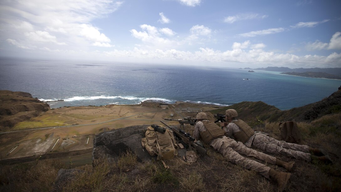 Scout snipers assigned to scout sniper platoon, 2nd Battalion, 3rd Marine Regiment, fire downrange at Range 10 aboard Marine Corps Base Hawaii, April 8, 2015. Marines improve their sniper proficiency by utilizing MCBH's natural resources to execute their training exercise. (U.S. Marine Corps photo by Lance Cpl. Julian Temblador, MCBH Combat Camera/Released)