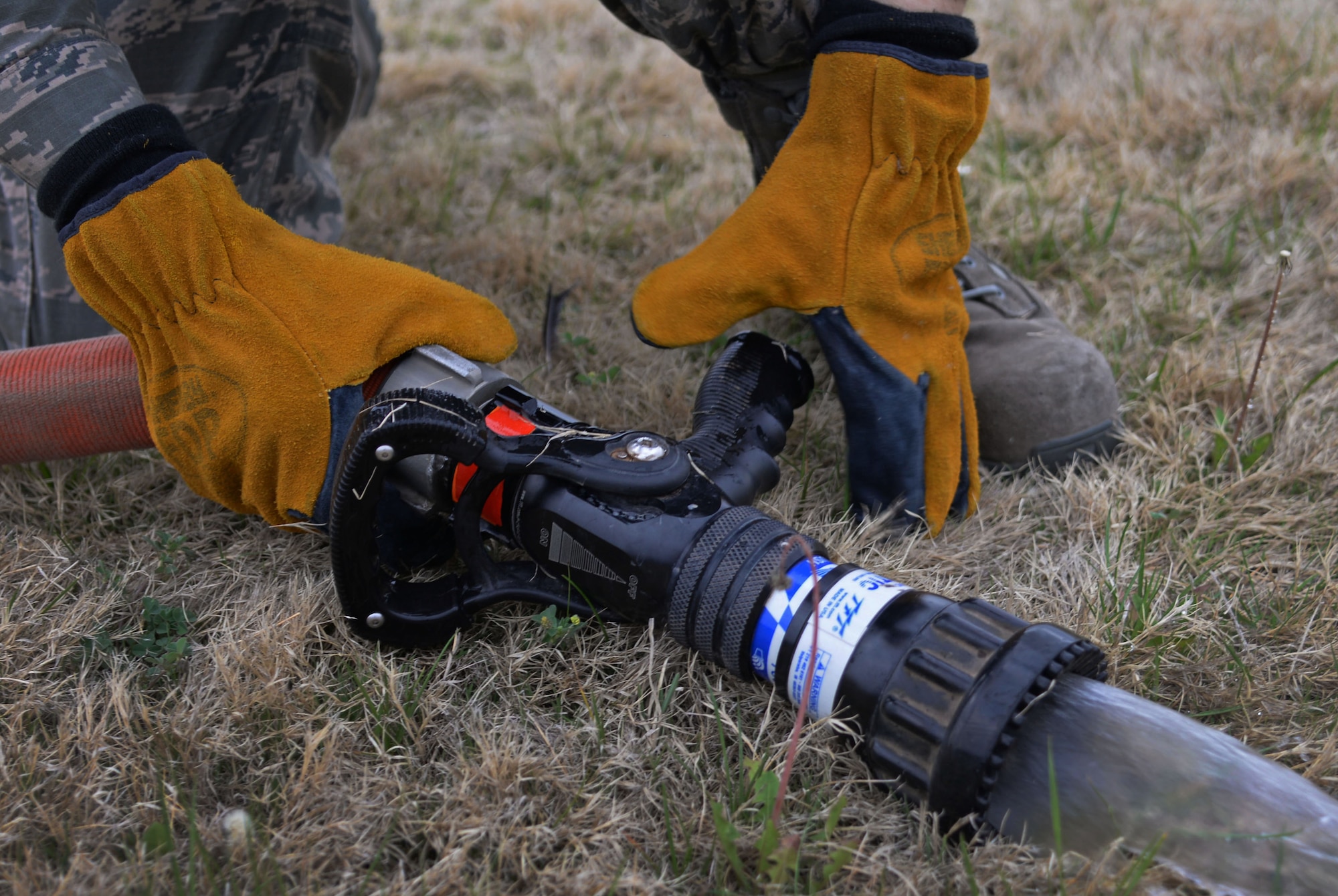 U.S. Air Force Airman 1st Class Tyler Foster, 27th Special Operations Civil Engineer Squadron firefighter, removes the main nozzle from a hose following ops checks April 8, 2015 at Cannon Air Force Base, N.M. Cannon’s fire protection crew tests all essential equipment following morning roll call. (U.S. Air Force photo/Staff Sgt. Alex Mercer) 
