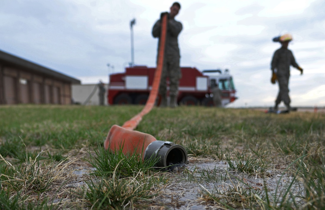 U.S. Air Force Airman 1st Class Alex Leonard, 27th Special Operations Civil Engineer Squadron firefighter, drains water out of a hose April 8, 2015 at Cannon Air Force Base, N.M. Water needs to be properly drained to minimize molding and reduce wear of equipment. (U.S. Air Force photo/Staff Sgt. Alex Mercer) 
