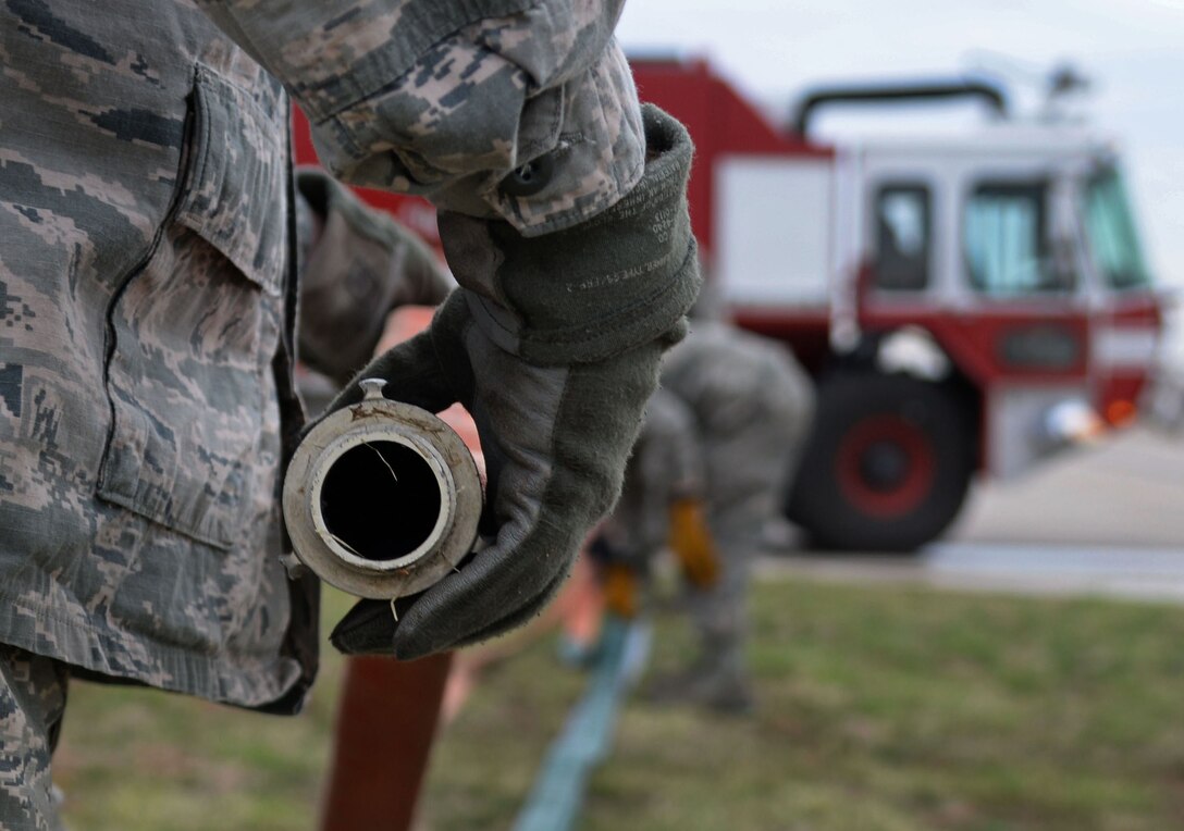 U.S. Air Force firefighters with the 27th Special Operations Civil Engineer Squadron work together to store a fire hose after ops checks April 8, 2015 at Cannon Air Force Base, N.M. Several sets of hands make the task more efficient and less time consuming. (U.S. Air Force photo/Staff Sgt. Alex Mercer) 
