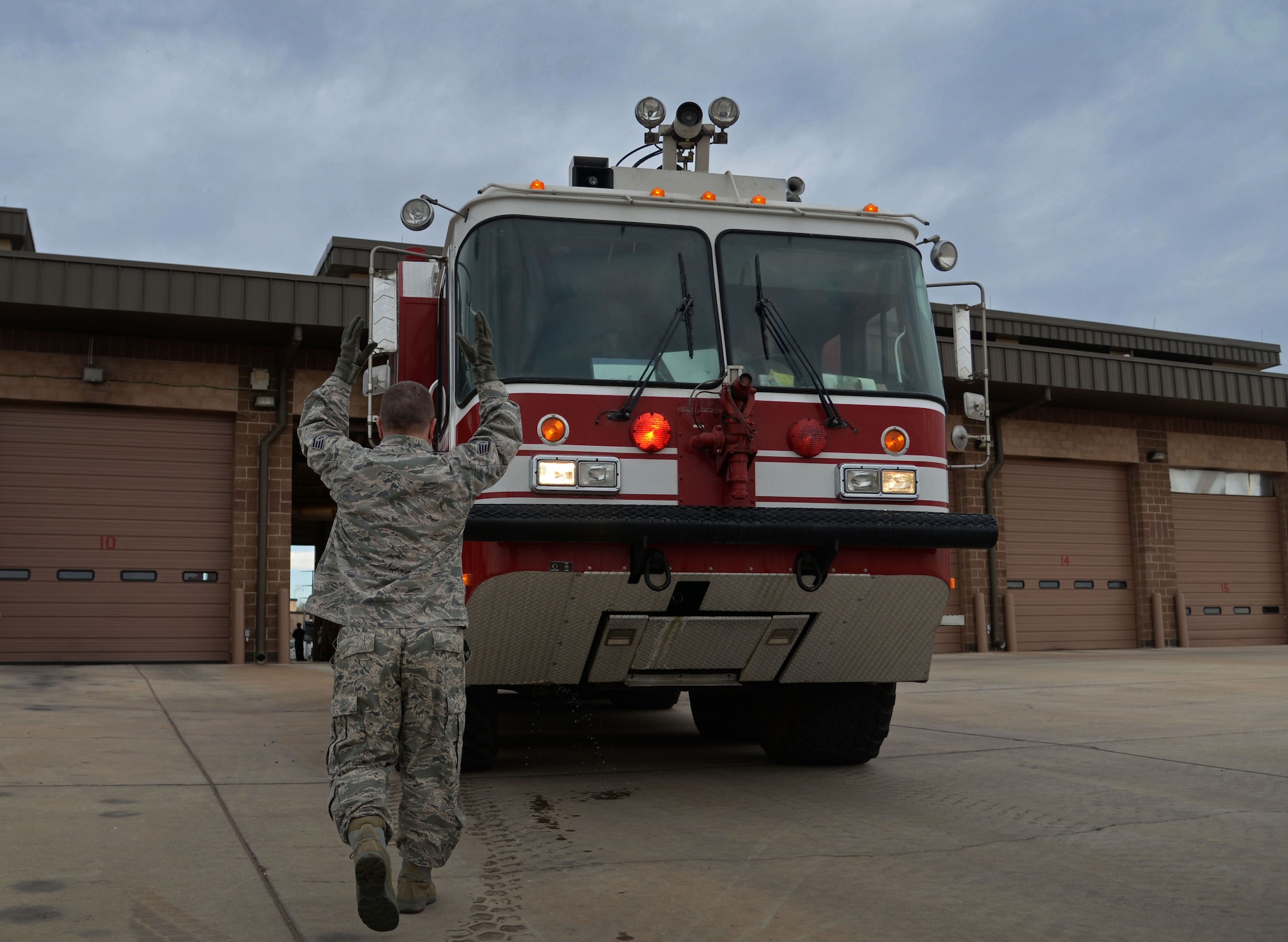 U.S. Air Force Staff Sgt. Joseph Peterson, 27th Special Operations Civil Engineer Squadron firefighters, helps guide a rescue engine back into its bay position April 8, 2015 at Cannon Air Force Base, N.M. Once crews have inspected and tested all equipment and vehicles, they are able to start other duties and training for the day. (U.S. Air Force photo/Staff Sgt. Alex Mercer) 
