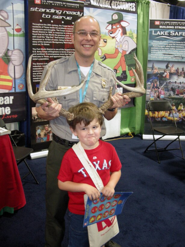 Fort Worth District Community Resource Coordinator Chad Eller puts antlers on his young charge during Earth Day Texas.