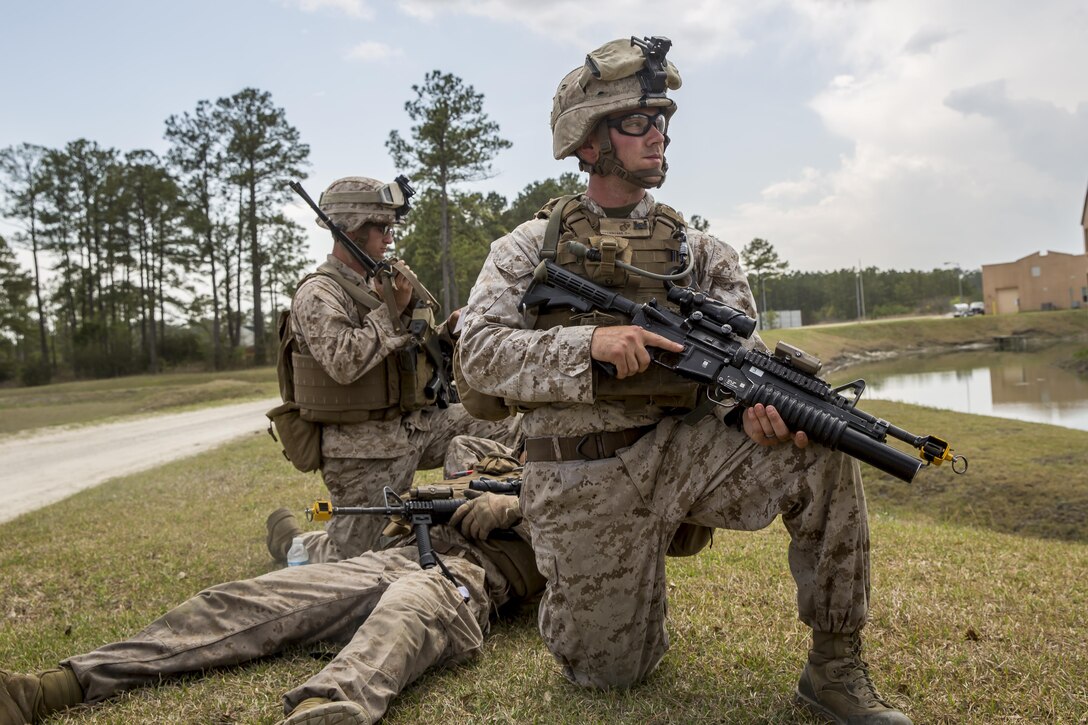 Corporal Tanner Pollock, a squad leader with 2nd Combat Engineer Battalion, 2nd Marine Division, and Fort Wayne, Ind. native, holds security while Lance Cpl. Ryan Zerites, a combat engineer with 2nd CEB, and Greensboro, N.C. native, calls in a 9-line medical evacuation request during Military Operations in Urban Terrain, or MOUT, training aboard Camp Lejeune, N.C., April 8, 2015. The training included Marines going out in squad sized elements to attack an objective being held by Marines in the defensive position after the squad leaders built terrain models and informed their Marines on avenues of approach and objectives. (U.S. Marine Corps photo by Cpl. Krista James/Released)

