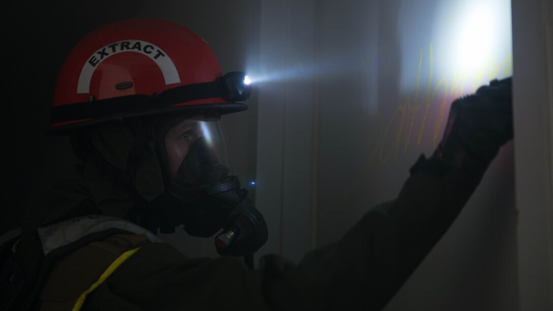 An extract Marine marks a bathroom door to indicate that it has been searched during Exercise Silent Ghost outside St. Elizabeths East hospital in Washington, D.C. April 7, 2015. The exercise was a simulated chemical, biological, radiological, nuclear and high yield explosive incident.
