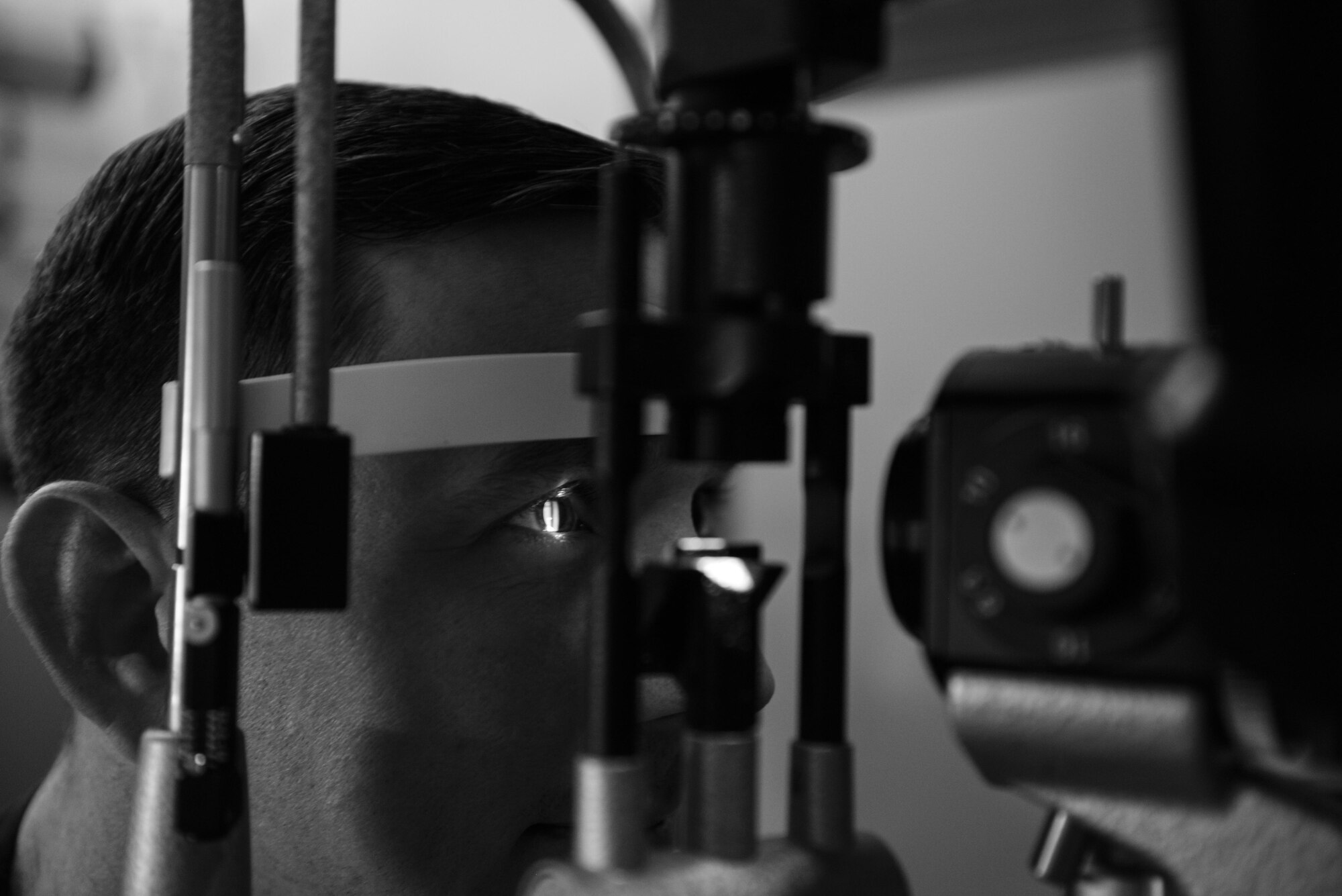 Master Sgt. Andrew Maresh, 1st Special Operations Wing operations security manager, looks through a slit-lamp during a routine eye exam at the 1st Special Operations Medical Group on Hurlburt Field, Fla., April 8, 2015. A slit-lamp is an instrument consisting of a high-intensity light source that can be focused to shine a thin sheet of light into the eye to measure eye sight health. (U.S. Air Force photo/Senior Airman Christopher Callaway) 
