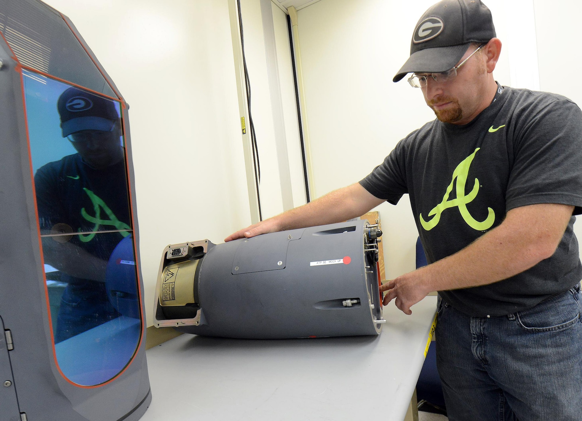 Jeffrey Nauss, a 402nd Electronics Maintenance Group electronics technician, performs optic alignment and adjustment procedures on the rotating gimble assembly of a Sniper XR Advanced Targeting Pod Sept. 5, 2015, at Robins Air Force Base, Ga. (U.S. Air Force photo/Tommie Horton)