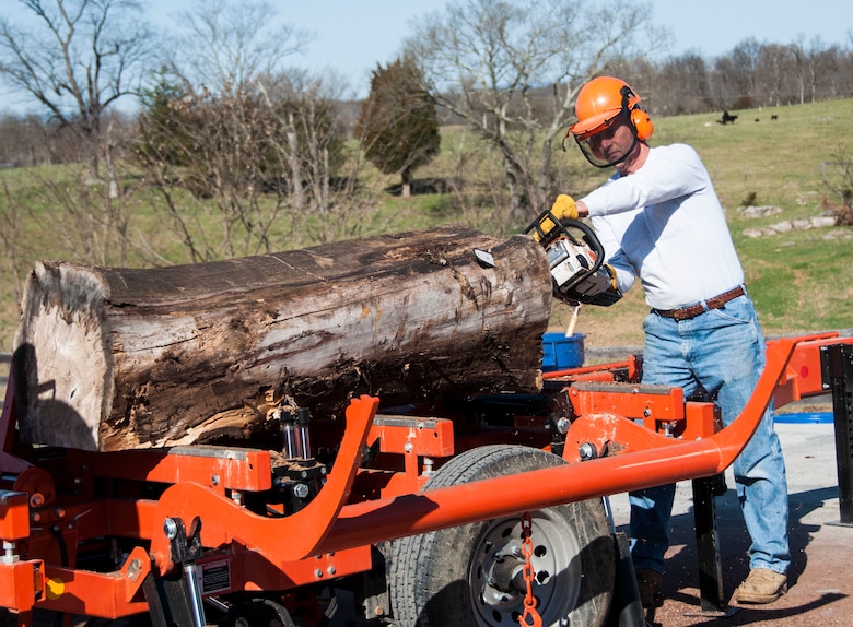 Retired Col. Ronald Light trims a log to better fit the sawmill at Lighthouse Woodworking. April 6. 