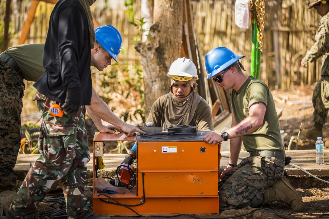 A member of the Armed Forces of the Philippines, along with U.S. Marines Lance Cpl. Michael Cameron and Lance Cpl. Bradley Trammell, both engineers with 9th Engineer Support Battalion, bend rebar for a classroom at the Santa Lourdes High School in Puerto Princesa, Philippines, as part of humanitarian civic assistance projects during exercise Balikatan 2015, April 9. The exercise provides an opportunity for Philippine, Australian and U.S. forces to continue strengthening relationships and work together.