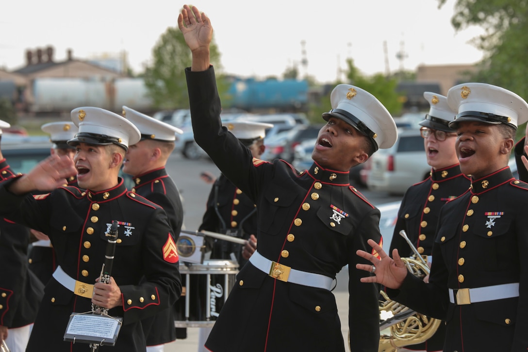 Cpl.’s Carlos Sierra and Marcus Robinson and Lance Cpl. Adam Chandler, members of Marine Corps Band New Orleans, sing and dance during the Bourbon Street Parade song performance at the New Orleans Zephyrs baseball game at Zephyr Field, April 9, 2015. By playing in different events, the band is able to enhance the connection and relationship between the Marine Corps and the New Orleans community. (U.S Marine Corps photo by Lance Cpl. Ian Ferro)