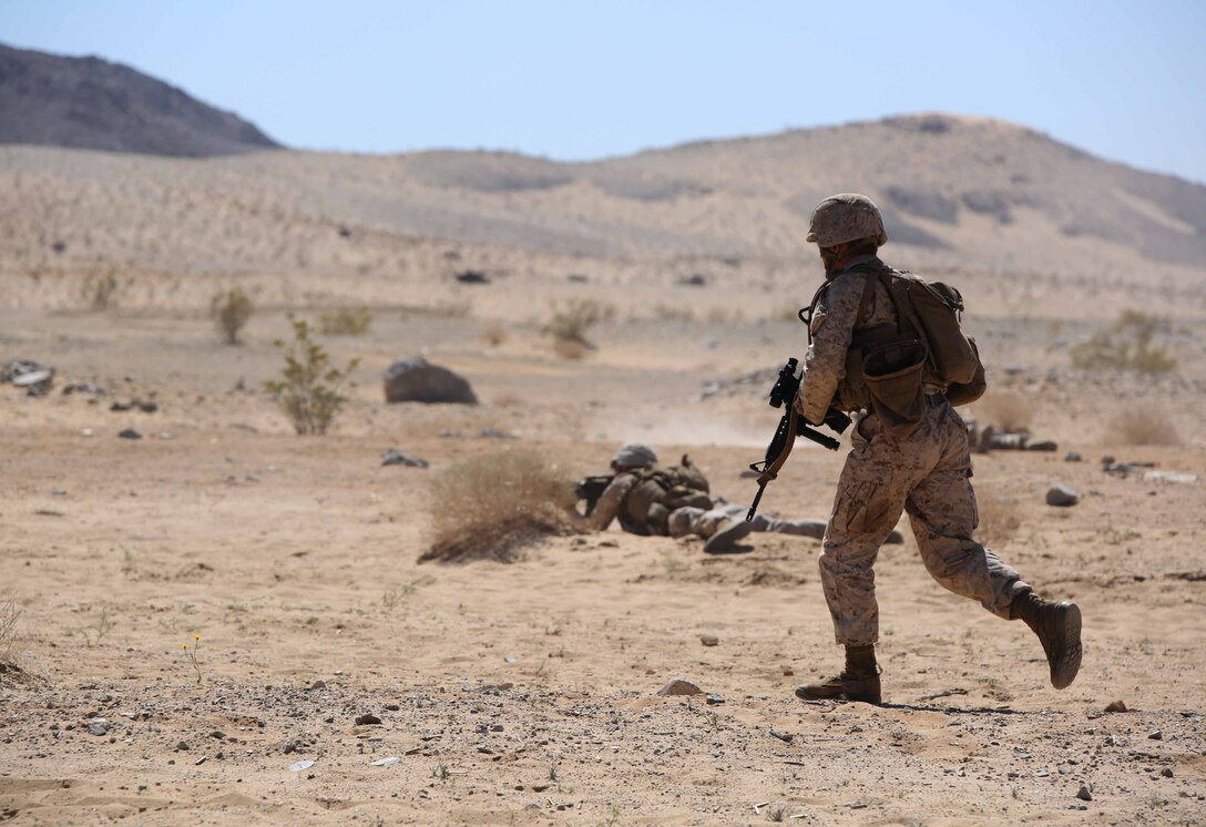 Sgt. Waldemar Diaz, rifleman, Company A, Ground Combat Element Integrated Task Force, advances down range during a Marine Corps Operational Test and Evaluation Activity assessment at Range 107, Marine Corps Air Ground Combat Center Twentynine Palms, California, April 4, 2015. From October 2014 to July 2015, the GCEITF will conduct individual and collective level skills training in designated ground combat arms occupational specialties in order to facilitate the standards-based assessment of the physical performance of Marines in a simulated operating environment performing specific ground combat arms tasks. (U.S. Marine Corps photo by Cpl. Paul S. Martinez/Released)