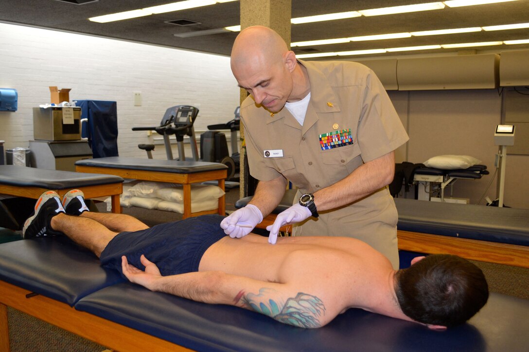 Lt. Cmdr. Charles Rainey, physical therapist at Naval Health Clinic Hawaii, performs trigger point dry needling to alleviate musculoskeletal pain and dysfunction, March 13, 2015. Rainey is the 2014 Navy Senior Physical Therapist of the Year competing with 111 active-duty physical therapists throughout the Navy. (U.S. Navy photo by Susan Schultz, Naval Health Clinic Hawaii Public Affairs)