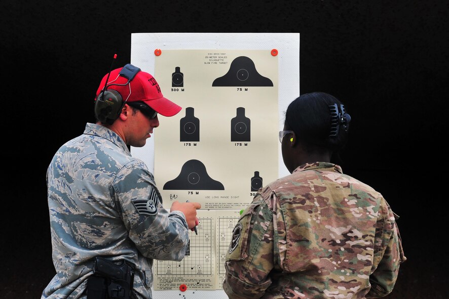 Staff Sgt. Darrin Miller, 1st Special Operations Security Forces Squadron combat arms training and maintenance instructor, shows a student her shot groupings, April 9, 2015, at Hurlburt Field, Fla. CATM instructors are subject matter experts on several weapon systems and must ensure Airmen are qualified to carry a weapon during deployments. (U.S. Air Force photo/Airman 1st Class Ryan Conroy)