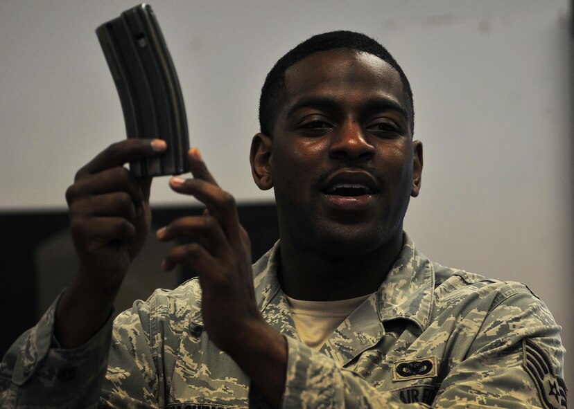 Staff Sgt. Brian Washington, 1st Special Operations Security Forces Squadron combat arms training and maintenance instructor, teaches Airmen how to load a magazine, April 9, 2015, at Hurlburt Field, Fla. CATM instructors are subject matter experts on operating, disassembling and maintaining all weapons held in the armory. (U.S. Air Force photo/Airman 1st Class Ryan Conroy) 