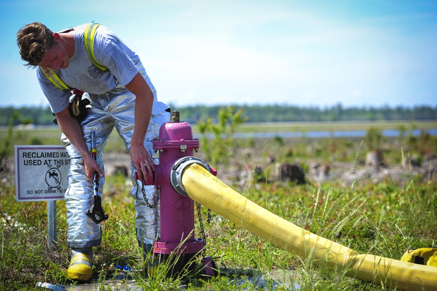 Senior Airman Benjamin Harwood, 1st Special Operation Civil Engineer Squadron fire rescueman, tightens a fire hydrant at Hurlburt Field, Fla., April 8, 2015. Hurlburt fire rescuemen are capable of mitigating structural, aircraft and wildland fires, provide lifesaving emergency medical services and performing hazardous material mitigation and special operations such as trench, confined space and high/low angle rescue. (U.S. Air Force photo by Senior Airman Meagan Schutter)