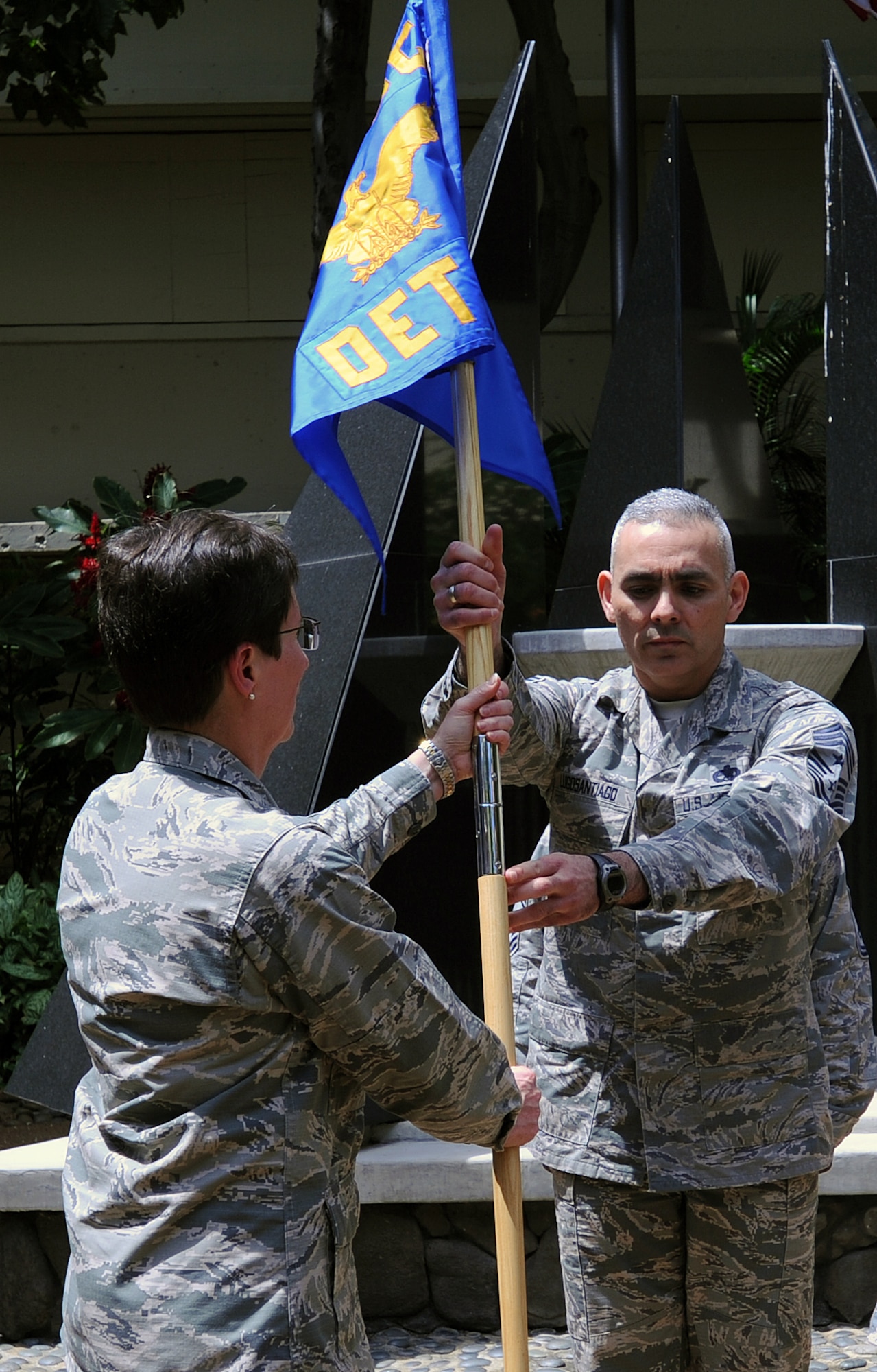 (Left to right) U.S. Air Force Maj. Gen. Theresa Carter, Air Force Installation and Mission Support Center commander, receives the guidon from Chief Master Sgt. Jose LugoSantiago, AFIMSC command chief, before handing it to the new AFIMSC Detachment 2 commander (not pictured) during an activation ceremony, April 9, 2015, Joint Base Pearl Harbor-Hickam, Hawaii. The Pacific detachment is the first detachment of the AFIMSC to activate in the Air Force and includes 60 Airmen who were formerly part of Headquarters Pacific Air Forces. (U.S. Air Force photo by Staff Sgt. Amanda Dick/Released)