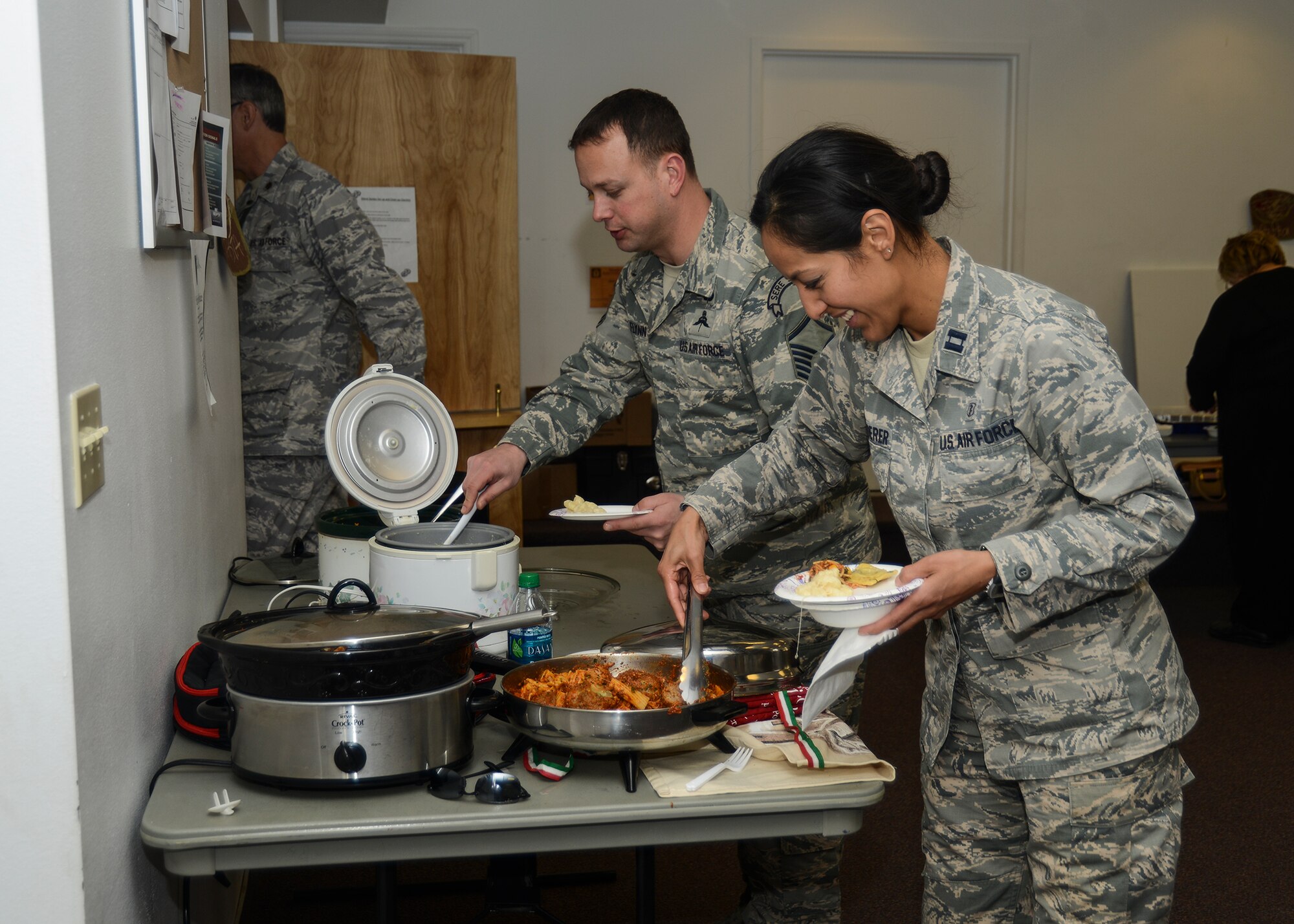 Master Sgt. Sean Flynn and Capt. Laura Pfledderer prepare for a pasta lunch at the Family Advocacy pasta dish contest. The event was held to highlight Child Abuse Awareness Month April 9 at the Chapel 2 Annex. (U.S. Air Force photo by Rebecca Amber)