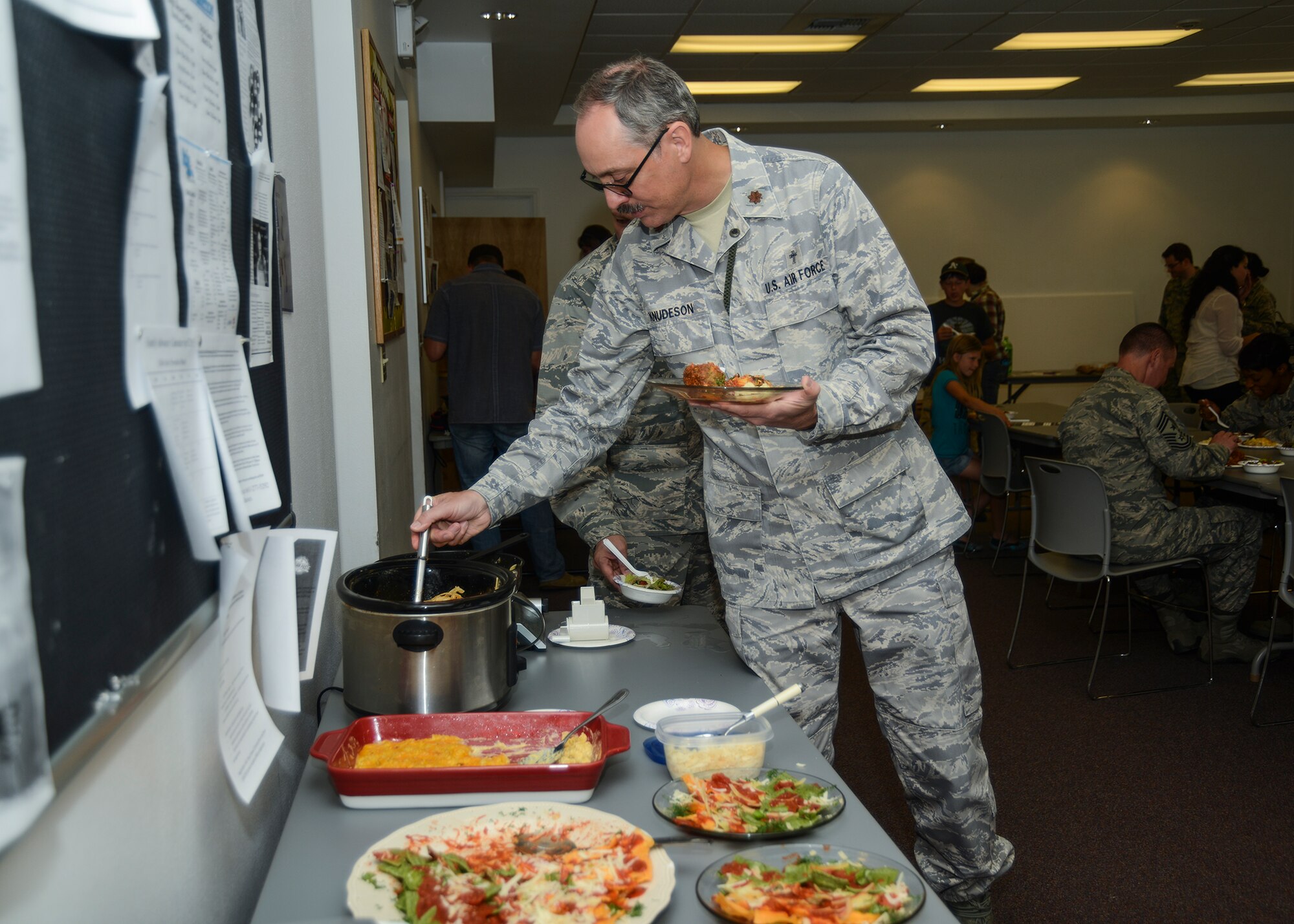 Chaplain (Maj.) Jason Knudeson, 412th Test Wing, deputy wing chaplain, fills up his plate with samples of all kinds of pasta. (U.S. Air Force photo by Rebecca Amber)