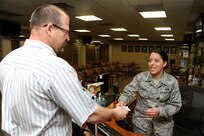 Airman 1st Class Valerie Camilo, 802nd Force Support Squadron customer service technician, assists a customer for an ID card appointment April 8, 2015 at Joint Base San Antonio-Randolph. (U.S. Air Force photo by Harold China/Released)