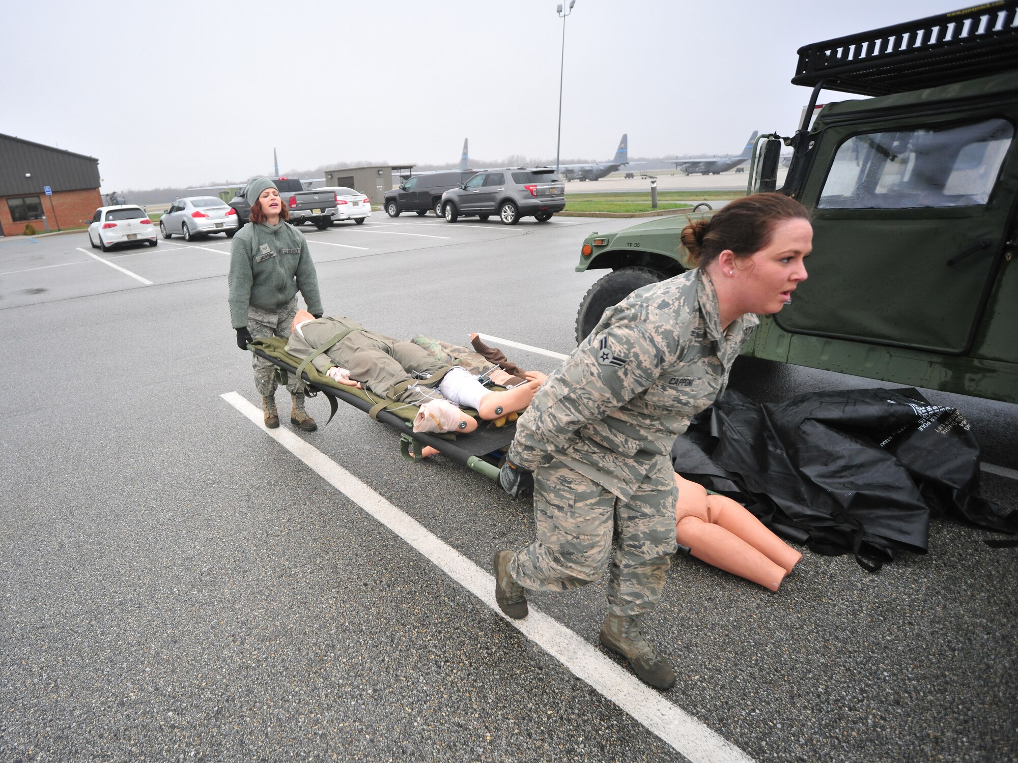 Airman 1st Class Jennifer Jackson and Airman Destinee Capponi, 166th Medical Group, Delaware Air National Guard, move a mannequin aboard a litter to place inside a Enroute Patient Staging System tent April 10, 2015 at the New Castle ANG Base, Del. The work is in preparation for use on April 11 during Operation Cyclone, a Delaware National Guard joint training exercise. Airmen and Soldiers will respond to a simulated tornado that has swept through New Castle County, and Army Black Hawk helicopters will evacuate simulated wounded personnel to the air base, with patients loaded onto C-130s for aerial evacuation. (U.S. Air National Guard photo by Staff Sgt. John Michaels)