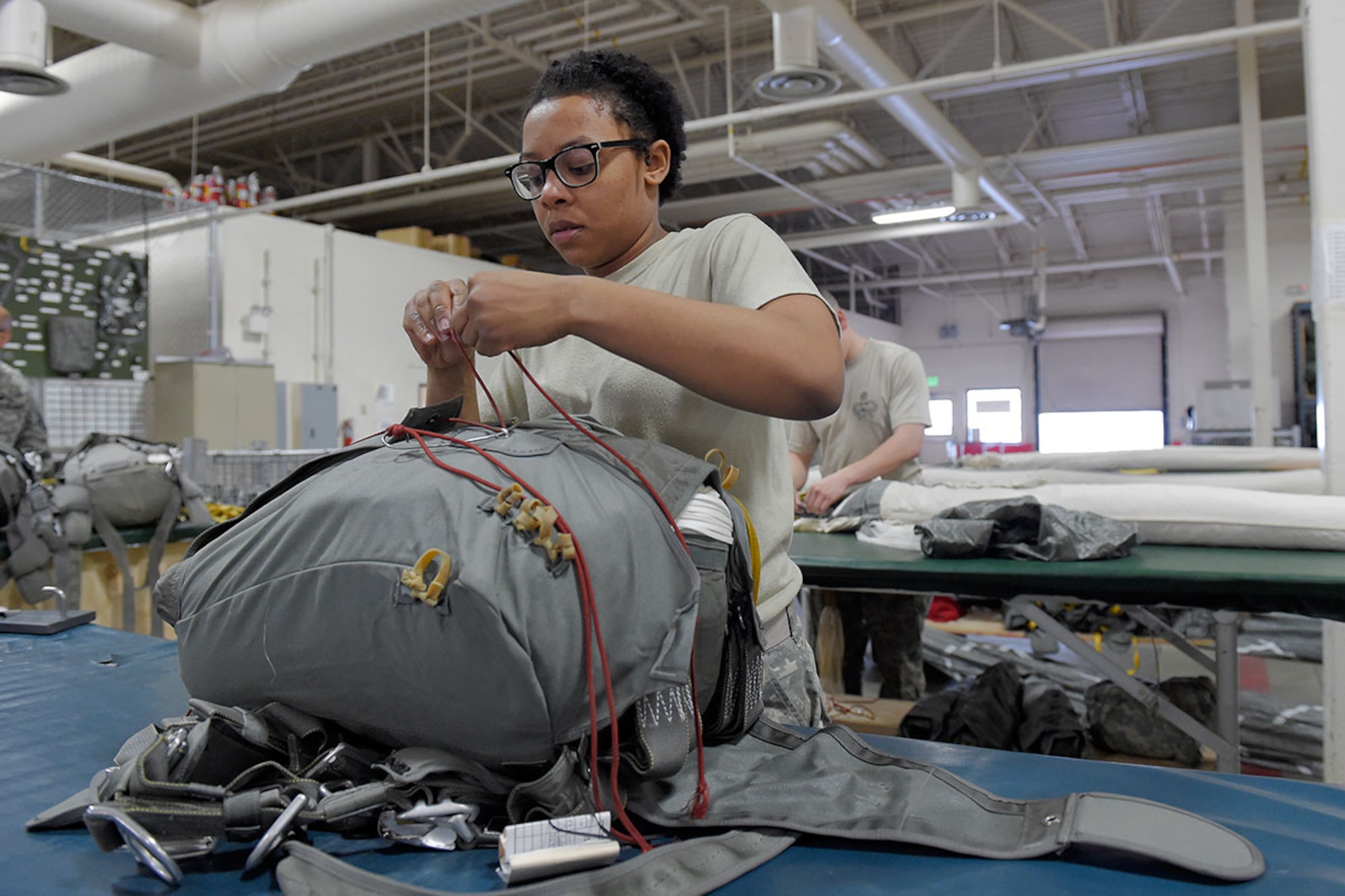 Spc. Brittany Williams, a native of Savannah, Ga., assigned to the 4th Quartermaster Company, 725 Brigade Support Battalion (Airborne), 4th Brigade Combat Team (Airborne), 25th Infantry Division, U.S. Army Alaska, packs a T-11 personnel parachute system on Joint Base Elmendorf-Richardson, Alaska, April 8, 2015. (U.S. Air Force photo/Alejandro Pena)




