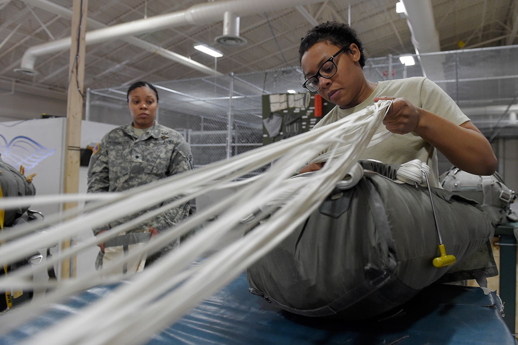 Spc. Brittany Williams, a native of Savannah, Ga., assigned to the 4th Quartermaster Company, 725 Brigade Support Battalion (Airborne), 4th Brigade Combat Team (Airborne), 25th Infantry Division, U.S. Army Alaska, packs a T-11 personnel parachute system on Joint Base Elmendorf-Richardson, Alaska, April 8, 2015. (U.S. Air Force photo/Alejandro Pena)



