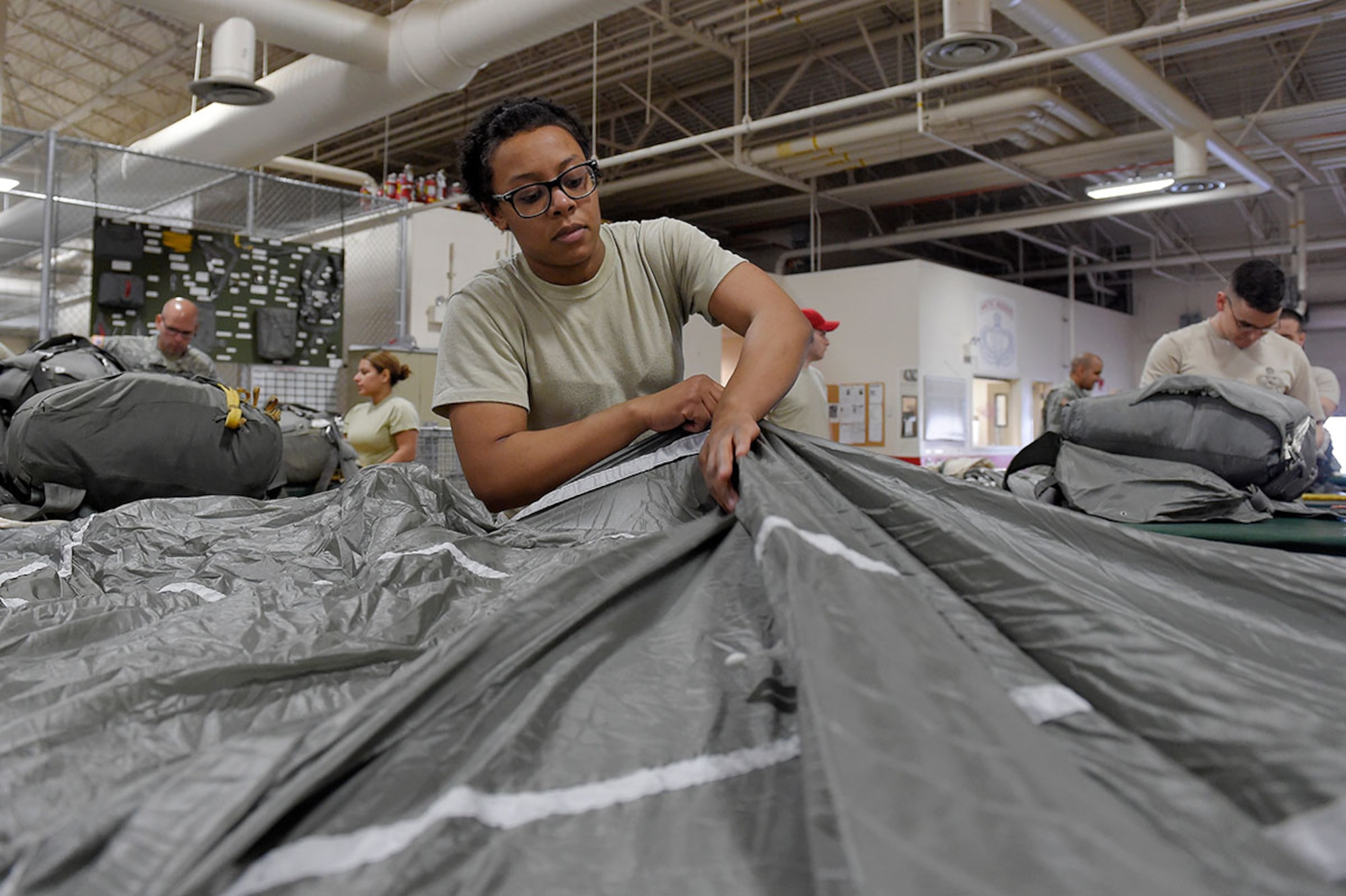 Spc. Brittany Williams, a native of Savannah, Ga., assigned to the 4th Quartermaster Company, 725 Brigade Support Battalion (Airborne), 4th Brigade Combat Team (Airborne), 25th Infantry Division, U.S. Army Alaska, packs a T-11 personnel parachute system on Joint Base Elmendorf-Richardson, Alaska, April 8, 2015. (U.S. Air Force photo/Alejandro Pena)


