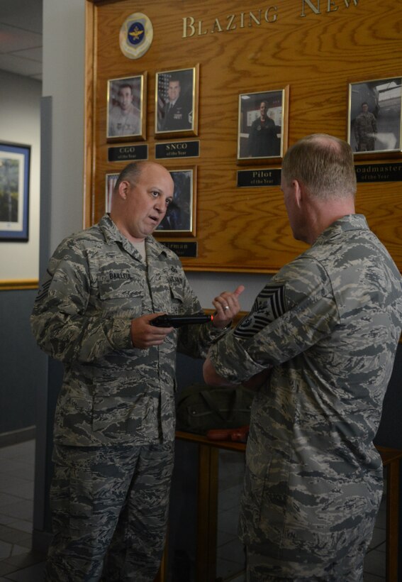 U.S. Air Force Master Sgt. Gregory Bailleul, 317th Operations Support Squadron, explains to Chief Master Sgt. of the Air Force James A. Cody how the survival, evasion, resistance and escape training offered by the 317th is unique from that offered by other units across the Air Force April 6, 2015, at Dyess Air Force Base, Texas.  This training is made more realistic by giving aircrew members water training in a body of water, rather than a pool, in addition to providing members with mock weapons that shoot plastic bb's while practicing evasions. (U.S. Air Force photo by Airman 1st Class Autumn Velez/Released)