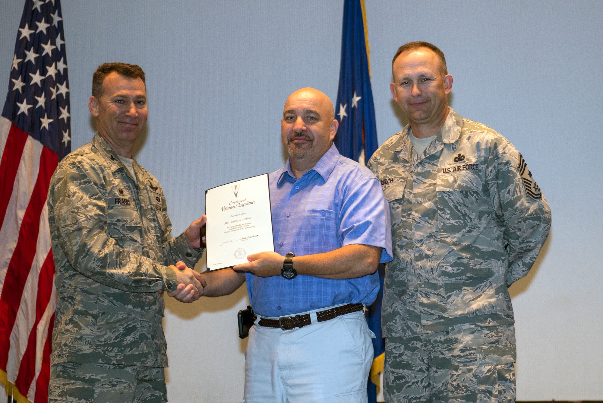 William Hebert, 23d Medical Support Squadron medical readiness manager, receives the Volunteer Excellence Award from U.S. Air Force Col. Chad Franks, 23d Wing commander, and Chief Master Sgt. David Kelch, 23d WG command chief, during the Volunteer Recognition Ceremony April 9, 2015, at Moody Air Force Base, Ga. Hebert has volunteered approximately 900 hours toward various Boy Scouts programs and under his leadership, the chapter received the 2014 Scouting’s Journey to Excellence Gold Level award for Troop Performance. (U.S. Air Force photo by Airman Greg Nash/Released)