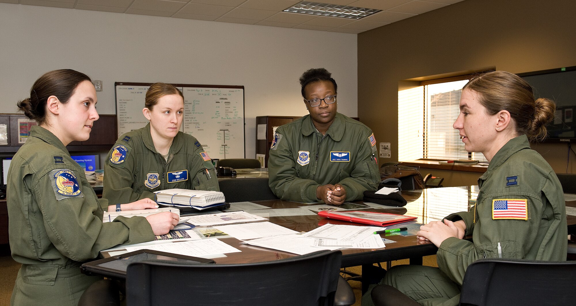 Capts. Kristina Himmelreich, left and Erin Killion, second from left, both pilots; and Senior Airman Tara Thorpe, loadmaster, second from right; listen to Capt. Ellen Canup, instructor pilot, right, during their mission aircrew briefing March 25, 2015, on Dover AFB, Del. The all-female aircrew from the 3d Airlift Squadron, air refueled with a KC-135 and practiced short runway assault landings during a local training mission. (U.S. Air Force photo/Roland Balik)