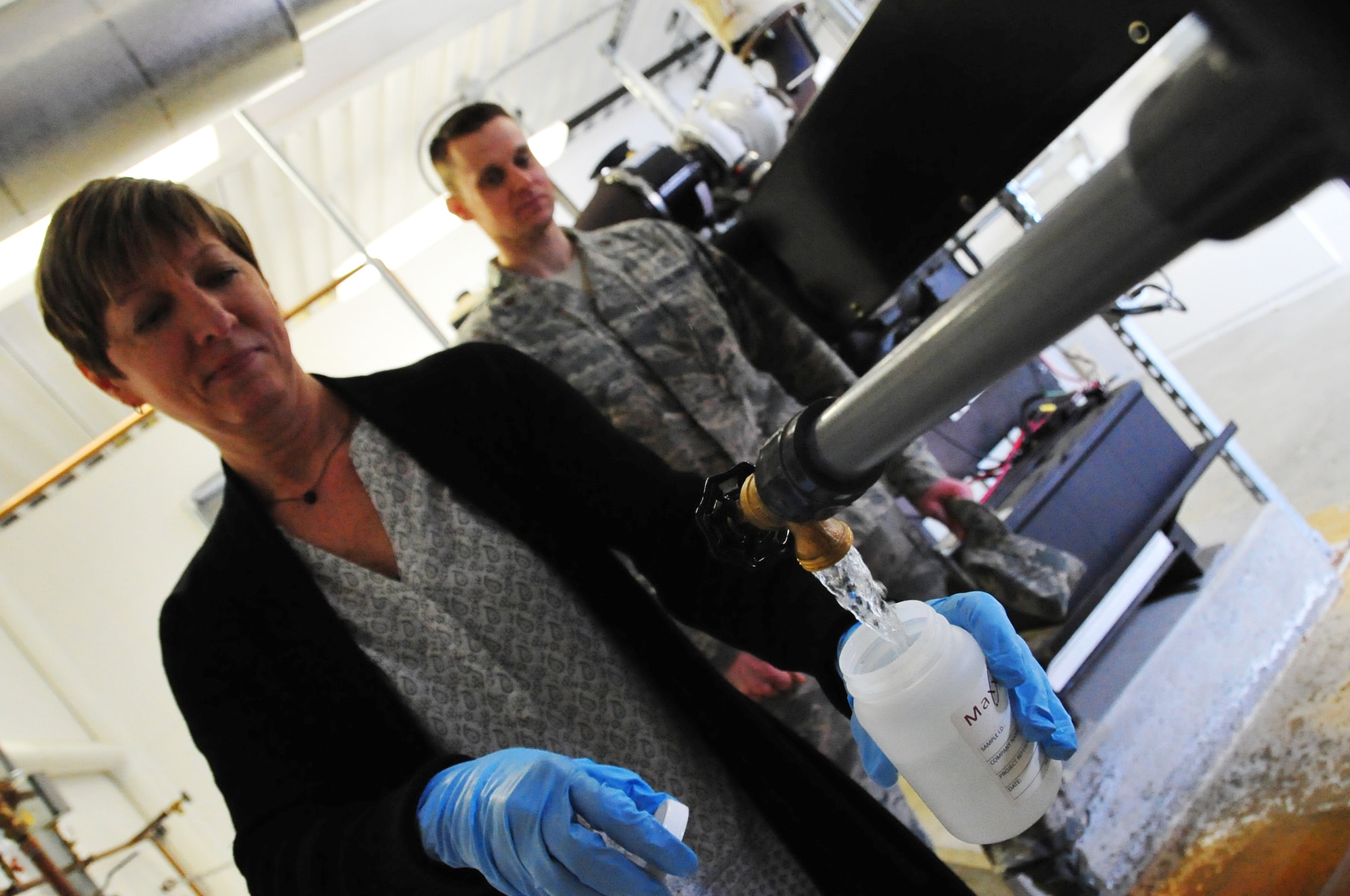 Kathy Levelier, the 354th Medical Operations Squadron bioenvironmental drinking wter program manager, collects a water sample at Eielson Air Force Base, Alaska, April 7, 2015.  The potable drinking water sample is collected, processed and shipped to a certified analysis lab.  (U.S. Air Force photo by Tech Sgt. Miguel Lara III/Released)