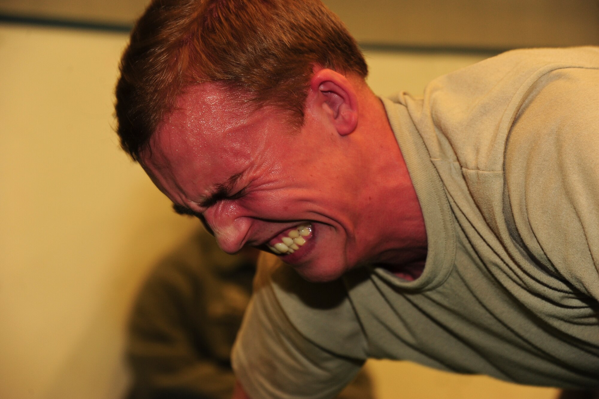 Airman Levi Jackson, 319th Comptroller Squadron financial services technician apprentice, strains during a pushup April 9, 2015, at the Fitness Center on Grand Forks Air Force Base, N.D. Jackson was one of many competitors in the Shirt’s Council Push Up-A-Thon. Competitors solicit pledges to help raise funds for the First Sergeants Council Operation Warm Heart, which provides charity and morale programs to GFAFB Airmen. (U.S. Air Force photo by Airman 1st Class Ryan Sparks/released)
