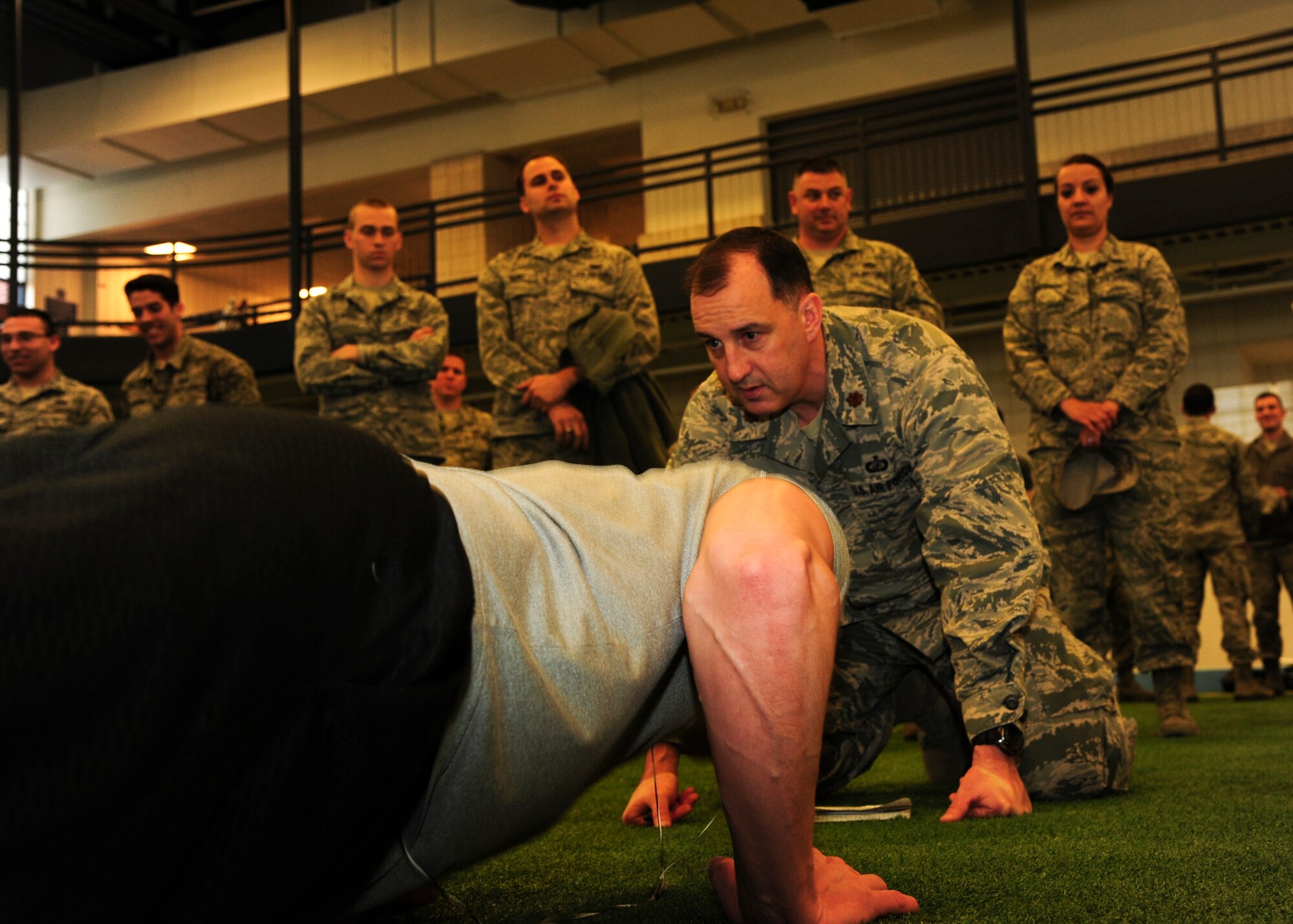 Maj. Frank Burks, 319th Comptroller Squadron commander, encourages Master Sgt. Keelan Rasmusson, 319th Logistics Readiness Squadron First Sergeant, during the 2015 Shirts’ Council Push Up-A-Thon April 9, 2015, at the Fitness Center on Grand Forks Air Force Base, N.D. Rasmusson is a member of the First Sergeants Council. The First Sergeants Council organized the Push Up-A-Thon to raise funds for Operation Warm Heart, which provides charity and morale programs to GFAFB Airmen. (U.S. Air Force photo by Airman 1st Class Ryan Sparks/released)