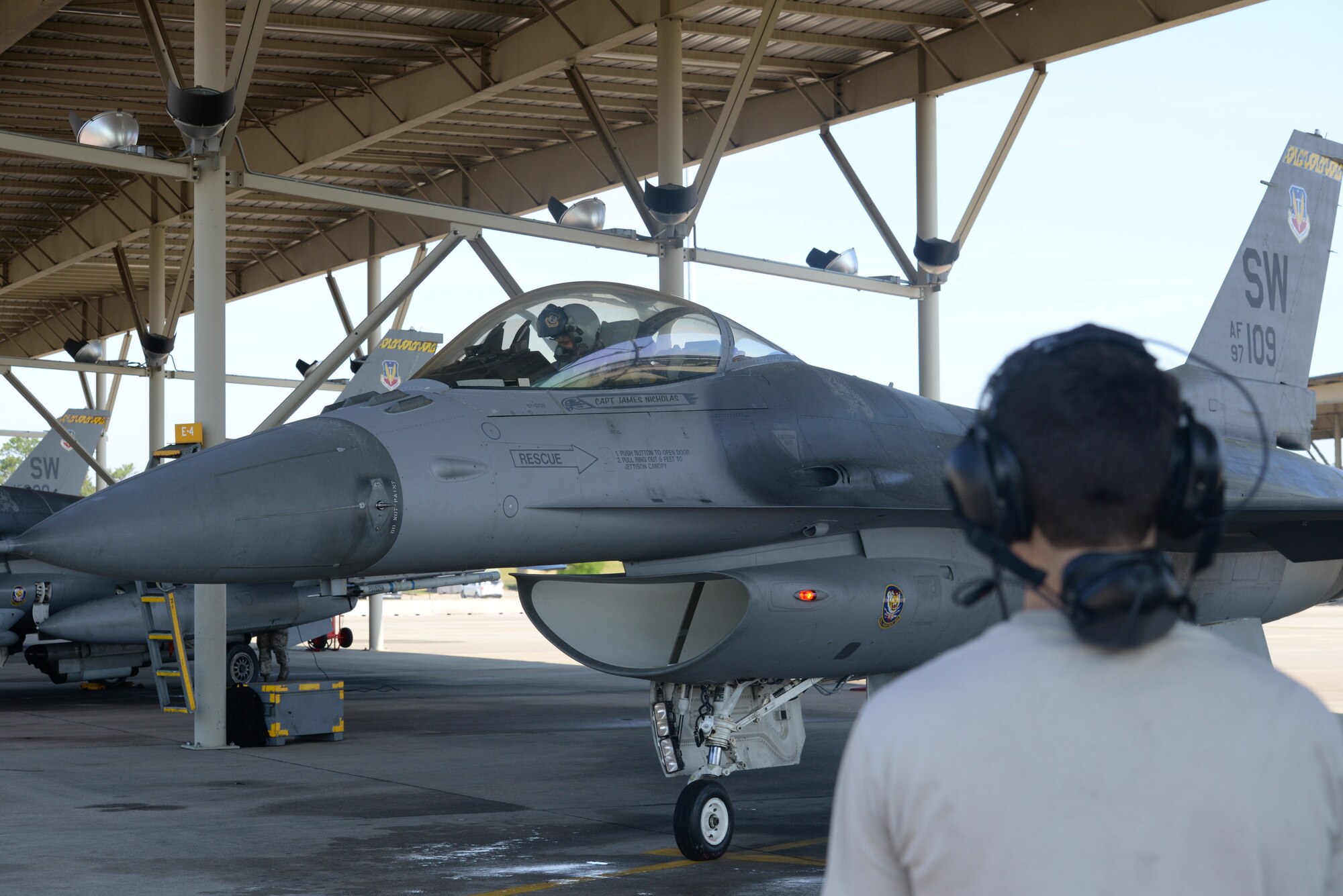 U.S. Air Force Maj. Mike Chebino, 9th Air Force aide de Camp to Maj. Gen. H.D. Polumbo Jr., 9th Air Force commander, conducts a pre-flight systems check in an F-16CM Fighting Falcon while Senior Airman Rafael Martinez, 20th Aircraft Maintenance Squadron dedicated crew chief, readies to marshal him out for takeoff at Shaw Air Force Base, S.C., April 8, 2015. The jet last flew on July 2, 2013, when it was damaged during landing procedures here, now 646 days later, after Martinez repaired the jet, it flew again. (U.S. Air Force photo by Senior Airman Jonathan Bass/Released)