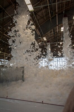 Fire suppression foam engulfs a maintenance hangar as part of a test of the installation’s high expansion foam discharge in the repair aircraft maintenance hangar April 8, 2015, at Fairchild Air Force Base, Wash. The test allowed the installation to assess whether the system was capable of meeting essential milestones required for full certification including covering at least 90 percent of the aircraft’s silhouette and covering the entire hangar floor with at least one meter of foam within four minutes. This test proved the installation’s primary maintenance hangar is ready for most situations. (U.S. Air Force photo/Staff Sgt. Benjamin W. Stratton)