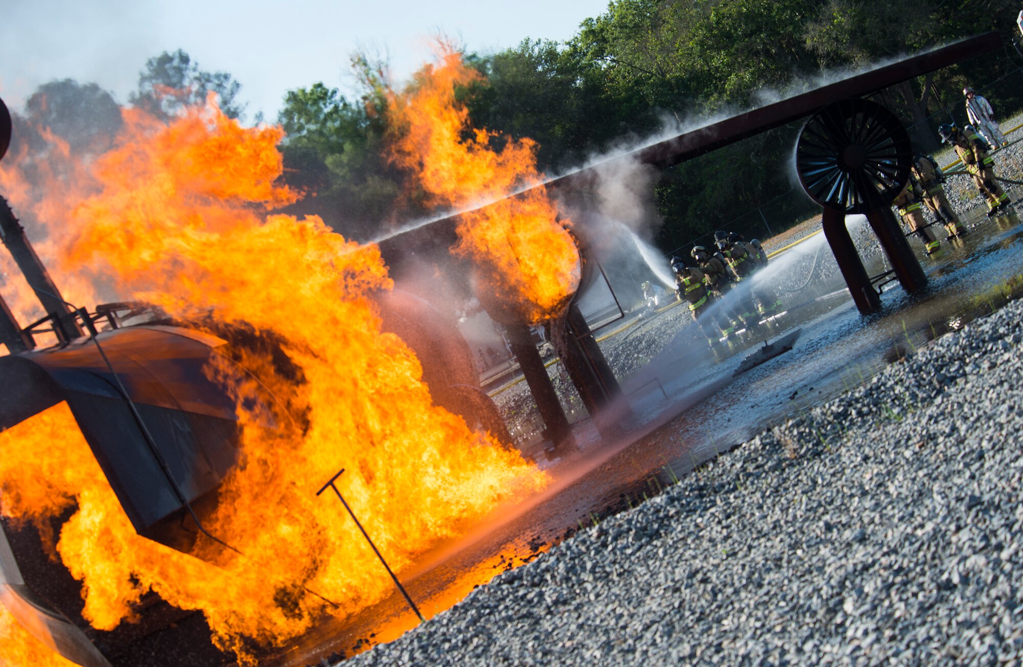 Firefighters from the 23d Civil Engineer Squadron and the Valdosta Fire Department, extinguish the flames during joint live fire training April 8, 2015, at Moody Air Force Base, Ga. Moody has a mutual aid agreement with Valdosta and two surrounding counties to support various local services. (U.S. Air Force photo by Airman 1st Class Ceaira Tinsley/Released)