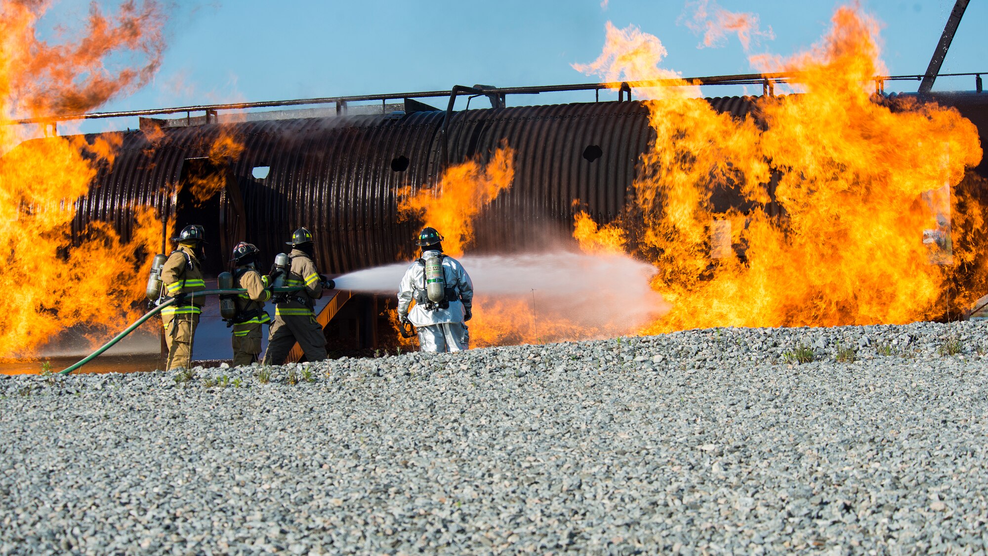 Firefighters from the 23d Civil Engineer Squadron and the Valdosta Fire Department, drench an aircraft with water during joint aircraft fire training April 8, 2015, at Moody Air Force Base, Ga. A real world aircraft fire can require between 13 and 17 firefighters to extinguish the fire. (U.S. Air Force photo by Airman 1st Class Ceaira Tinsley/Released)
