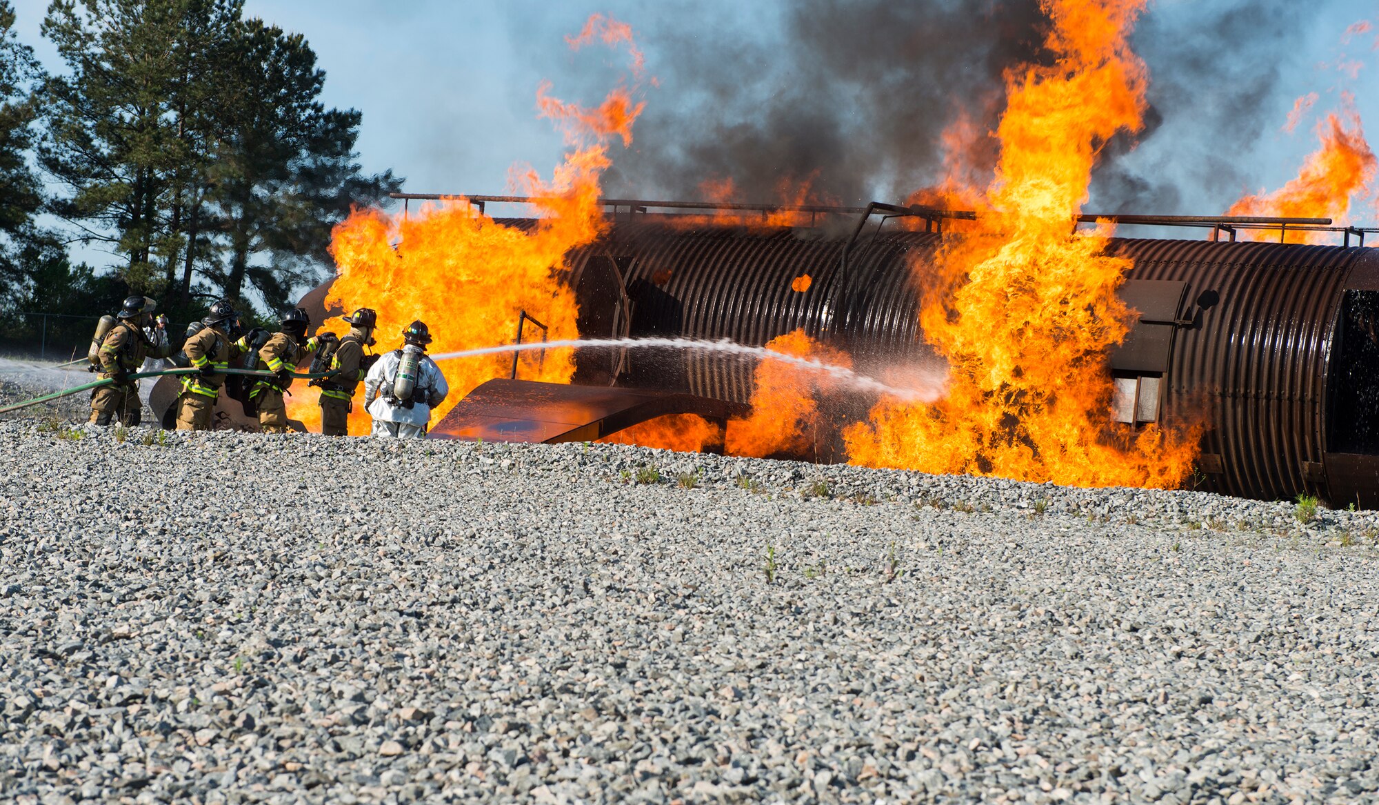 Firefighters from the 23d Civil Engineer Squadron and the Valdosta Fire Department, hose down a simulated aircraft with water during joint aircraft fire training April 8, 2015, at Moody Air Force Base, Ga. The training prepares the firefighters for a real world response time of three to five minutes. (U.S. Air Force photo by Airman 1st Class Ceaira Tinsley/Released)