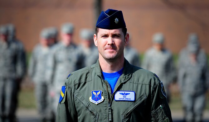 Lt. Col. Justin Grieve, 394th Combat Training Squadron director of operations, stands at attention during a wing retreat ceremony at Whiteman Air Force Base, Mo., March 27, 2015. A retreat ceremony signifies the end of a duty day and is also a way to pay tribute to the American flag. (U.S. Air Force photo by Staff Sgt. Nick Wilson/Released)