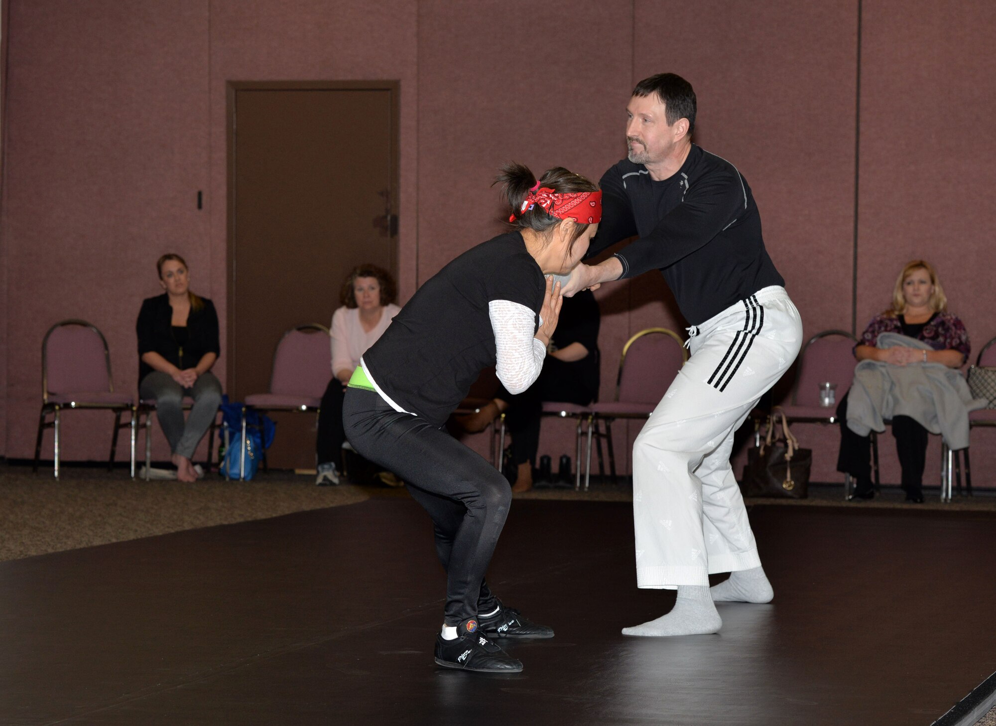 Randal Dannenfelser, engineer for Air Force Life Cycle Management Center and Camila Dannenfelser demonstrate self-defense strategies at the 11th annual Total Woman’s Training Expo hosted by Wright-Patterson Federal Woman’s Program and the Miami Valley Chapter of Federally Employed Women at the Hope Hotel and Conference Center March 25. The purpose of FWP and FEW organizations is the advancement and education of women in the federal workplace.  (U.S. Air Force photo by Michelle Gigante) 

