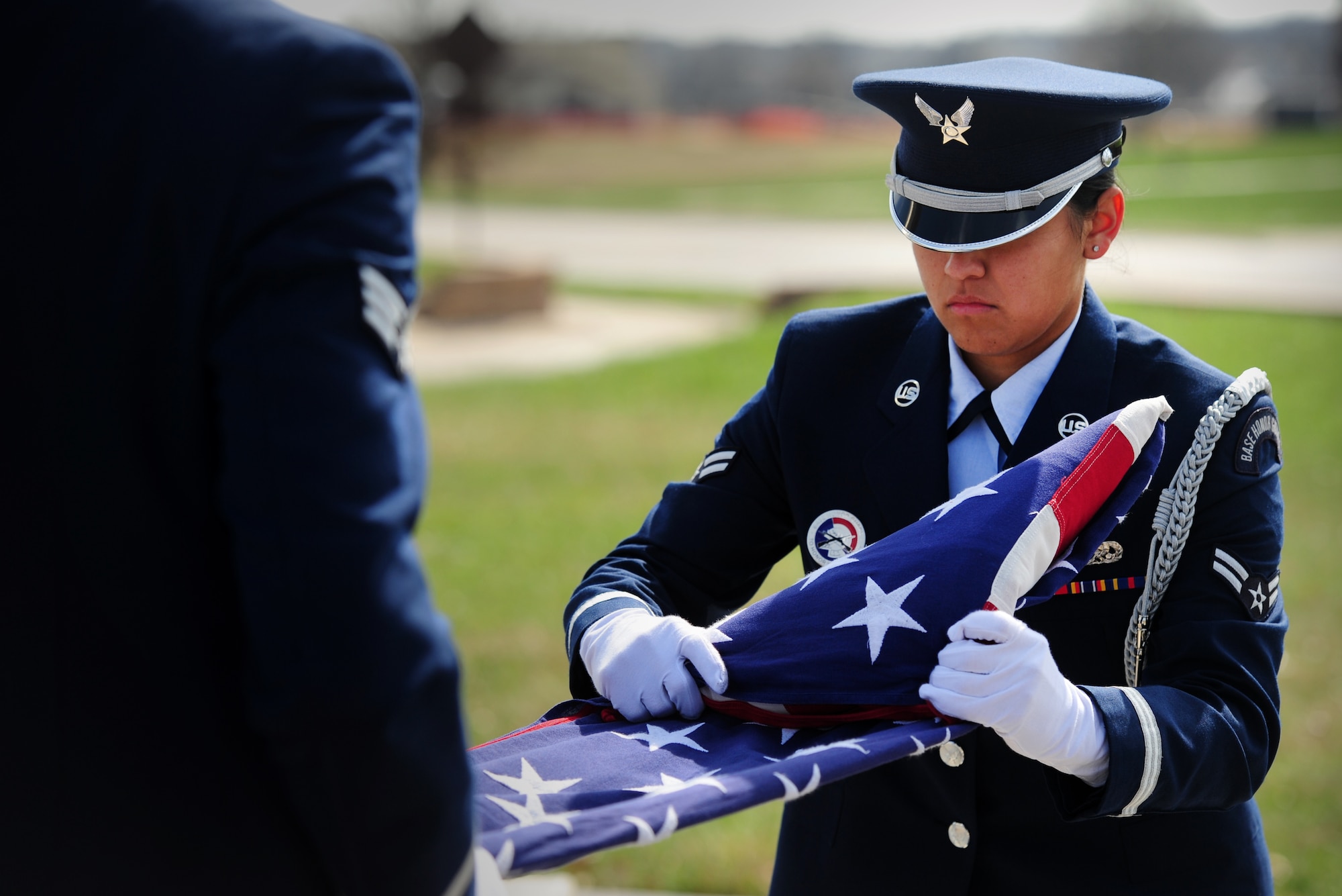 Airman 1st Class Desirae Yazzie, Whiteman Air Force Base Honor Guard member, folds a flag during a wing retreat at Whiteman Air Force Base, Mo., March 27, 2015. A retreat ceremony signifies the end of a duty day and is also a way to pay tribute to the American flag. (U.S. Air Force photo by Staff Sgt. Nick Wilson/Released)